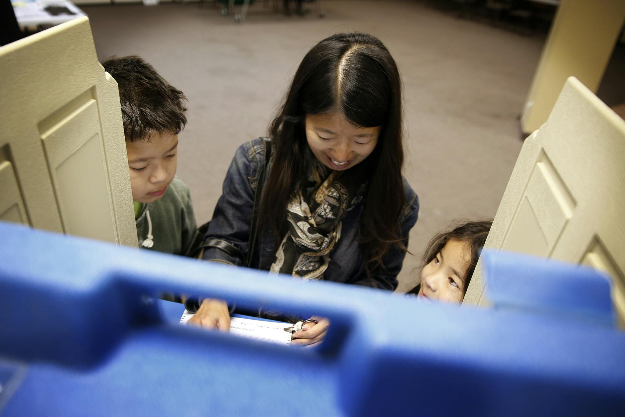 Beth Barbosa votes with her children Isaiah, left, 10, and Ella, 6, at Summit Church on election day in St. Paul. ] LEILA NAVIDI leila.navidi@startribune.com / BACKGROUND INFORMATION: Tuesday, November 4, 2014.