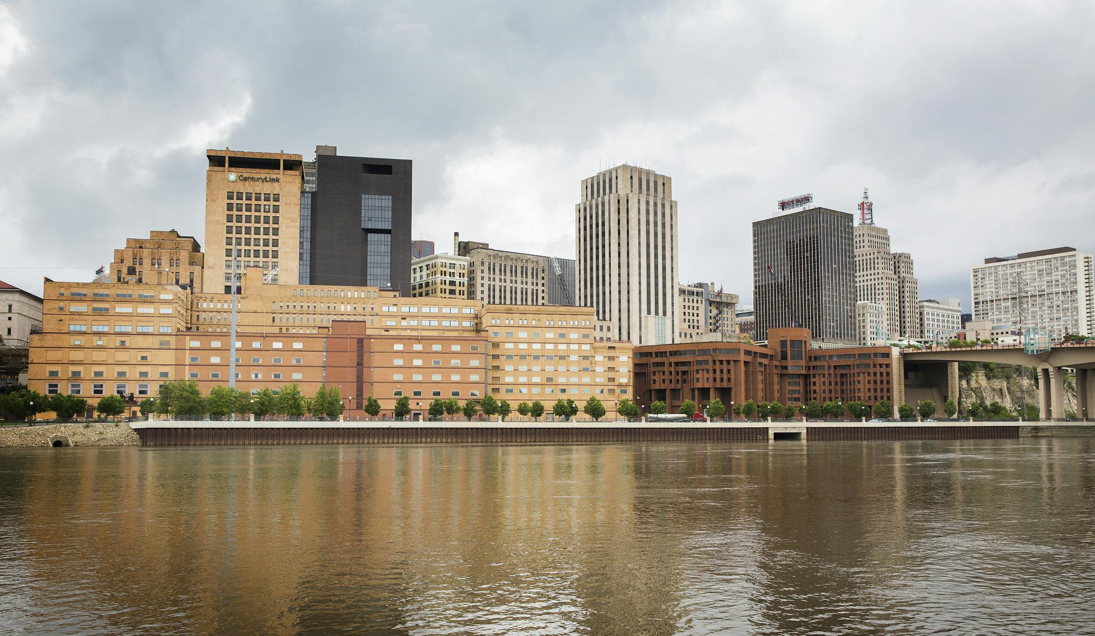 The former West Publishing building, long tan building on left, and former Ramsey County jail building, squat reddish-brown building on right, are seen from across the Mississippi River in downtown St. Paul on Friday, May 29, 2015. ] LEILA NAVIDI leila.navidi@startribune.com / BACKGROUND INFORMATION: This June, Ramsey County will begin razing the former West Publishing building and Ramsey County jail along the St. Paul's downtown river bluff to make way for a sale and new development of the area