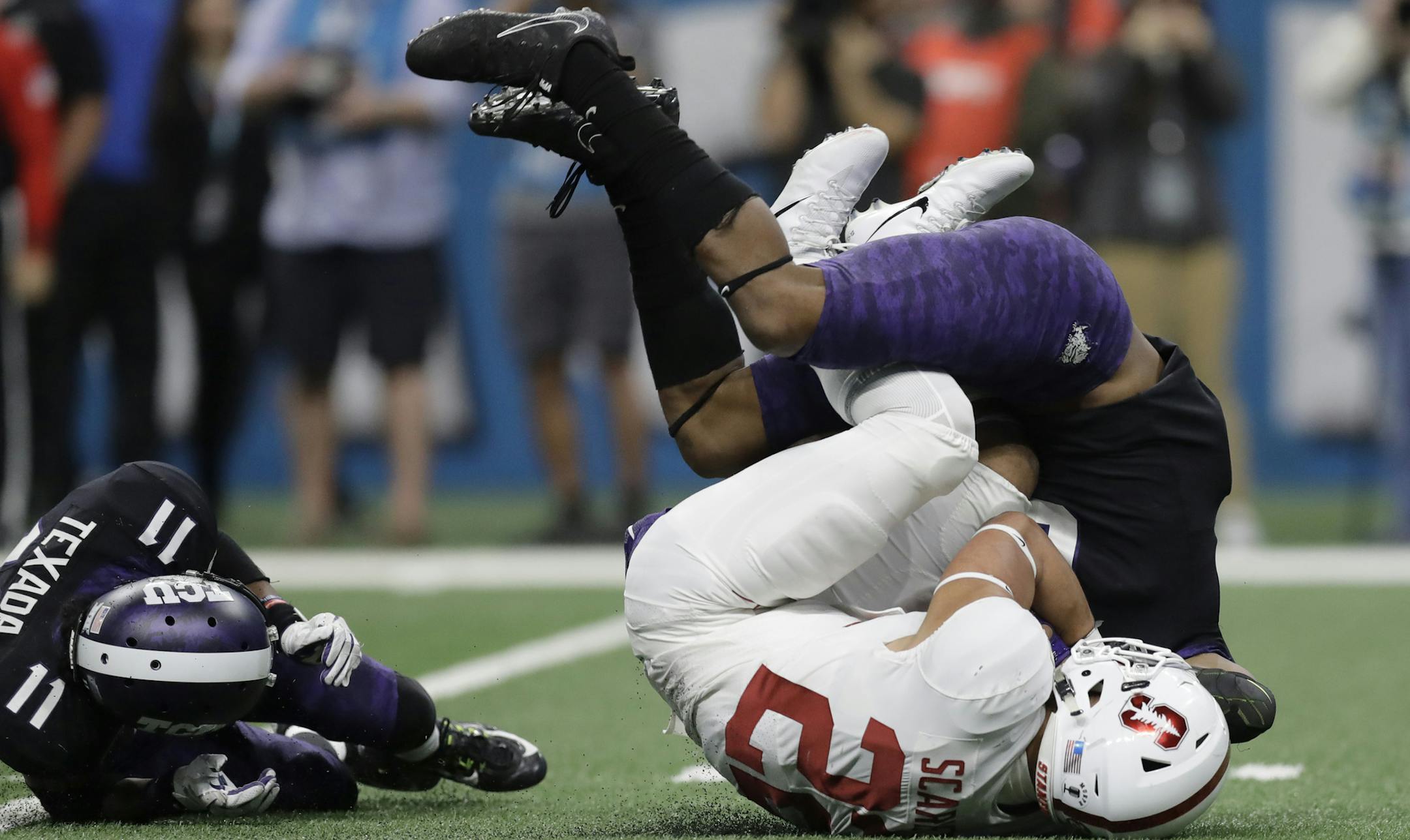 Stanford running back Cameron Scarlett (22) is dropped by TCU safety Innis Gaines, right, after a run during the second half of the Alamo Bowl NCAA college football game, Thursday, Dec. 28, 2017, in San Antonio. (AP Photo/Eric Gay)