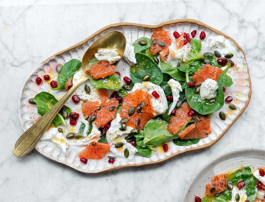 Spinach and mozzarella are tossed with a vinaigrette before being topped with caramelized grapefruit, pomegranate seeds and pumpkin seeds.
