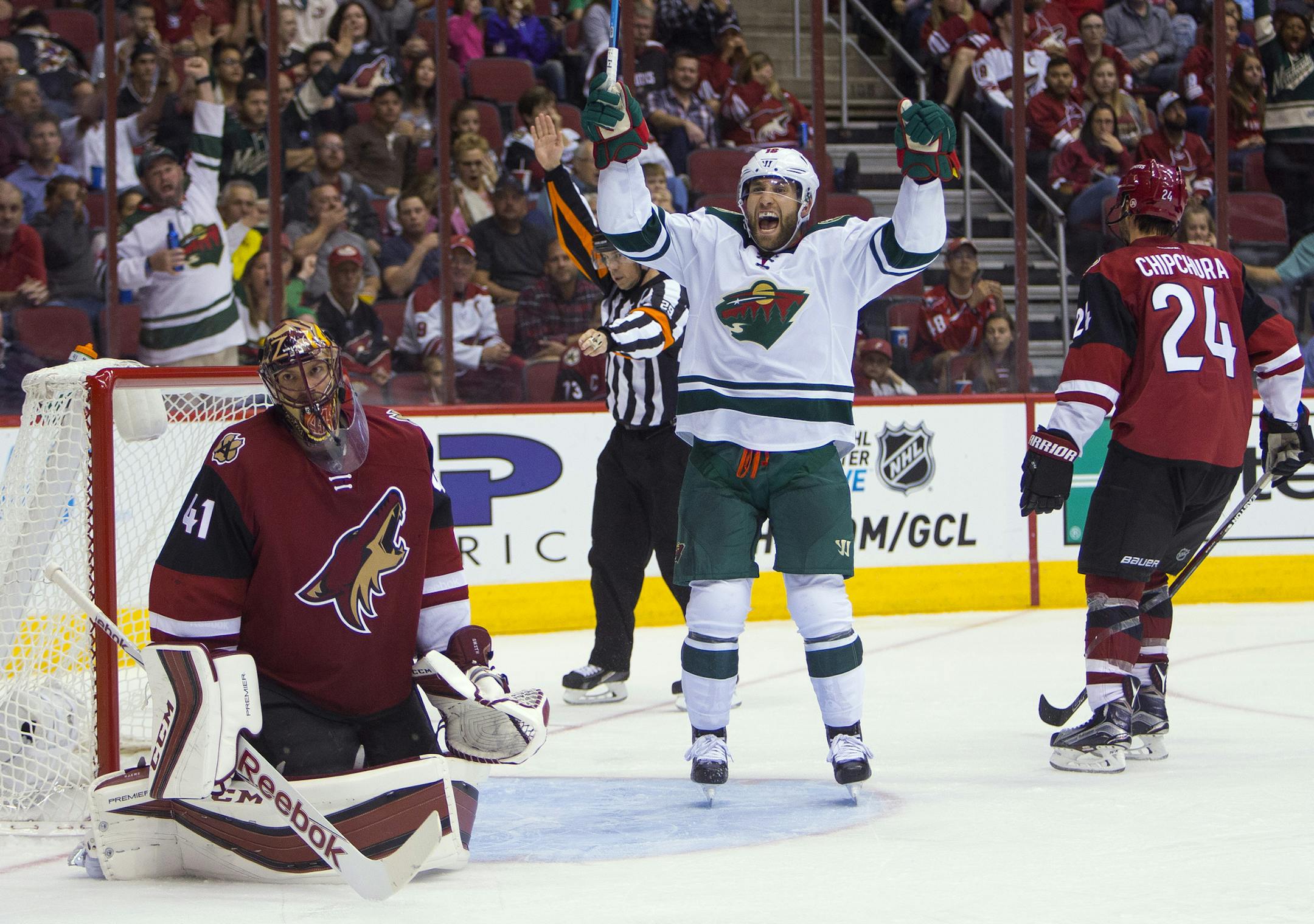 Minnesota Wild's Jason Zucker, center, reacts after Mikko Koivu scored a shorthanded goal past Arizona Coyotes' Mike Smith (41) during an NHL hockey game Thursday, Oct. 15, 2015, in Glendale, Ariz. (Patrick Breen/The Arizona Republic via AP)