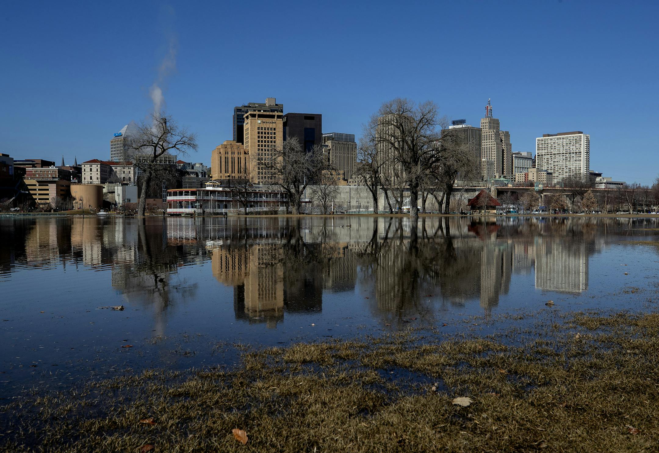 Downtown St. Paul reflected in the water flooding Harriet Island Regional Park on Monday afternoon. ] CARLOS GONZALEZ &#x2022; cgonzalez@startribune.com &#x2013; St. Paul, MN &#x2013; March 25, 2019, Harriet Island across from downtown St. Paul is starting to go under water due to spring flooding.