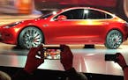 FILE - In this March 31, 2016 file photo, Tesla Motors unveils the new lower-priced Model 3 sedan at the Tesla Motors design studio in Hawthorne, Cali
