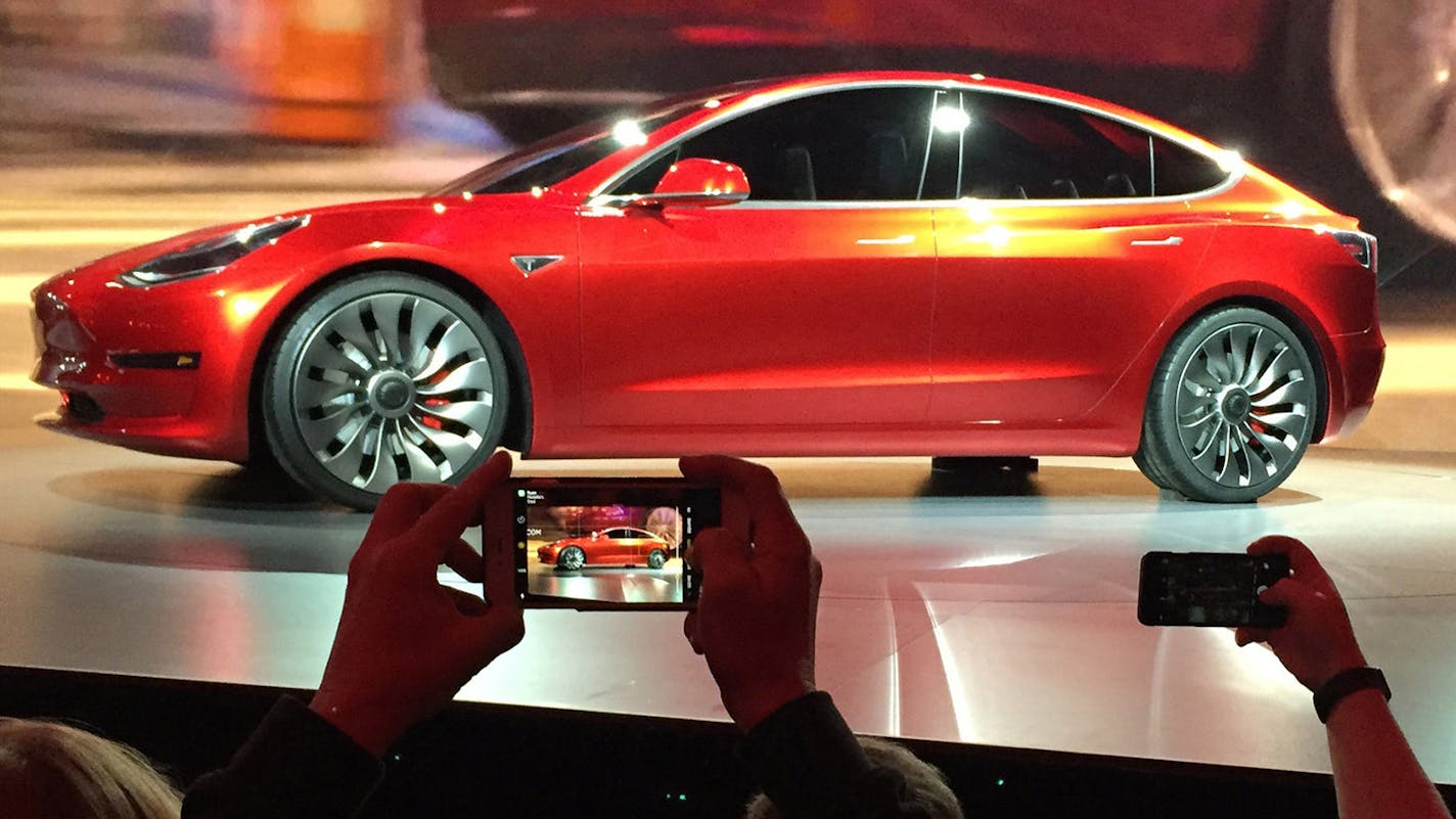 FILE - In this March 31, 2016 file photo, Tesla Motors unveils the new lower-priced Model 3 sedan at the Tesla Motors design studio in Hawthorne, Calif. More than 276,000 people pre-order the Tesla Model 3 in less than a week. Is it the &#xec;Tesla phenomenon,&#xee; or has the $35,000 electric car with a range of 200-plus miles taken finally taken the electric car to the masses. (AP Photo/Justin Pritchard) ORG XMIT: MIN2016041218251033