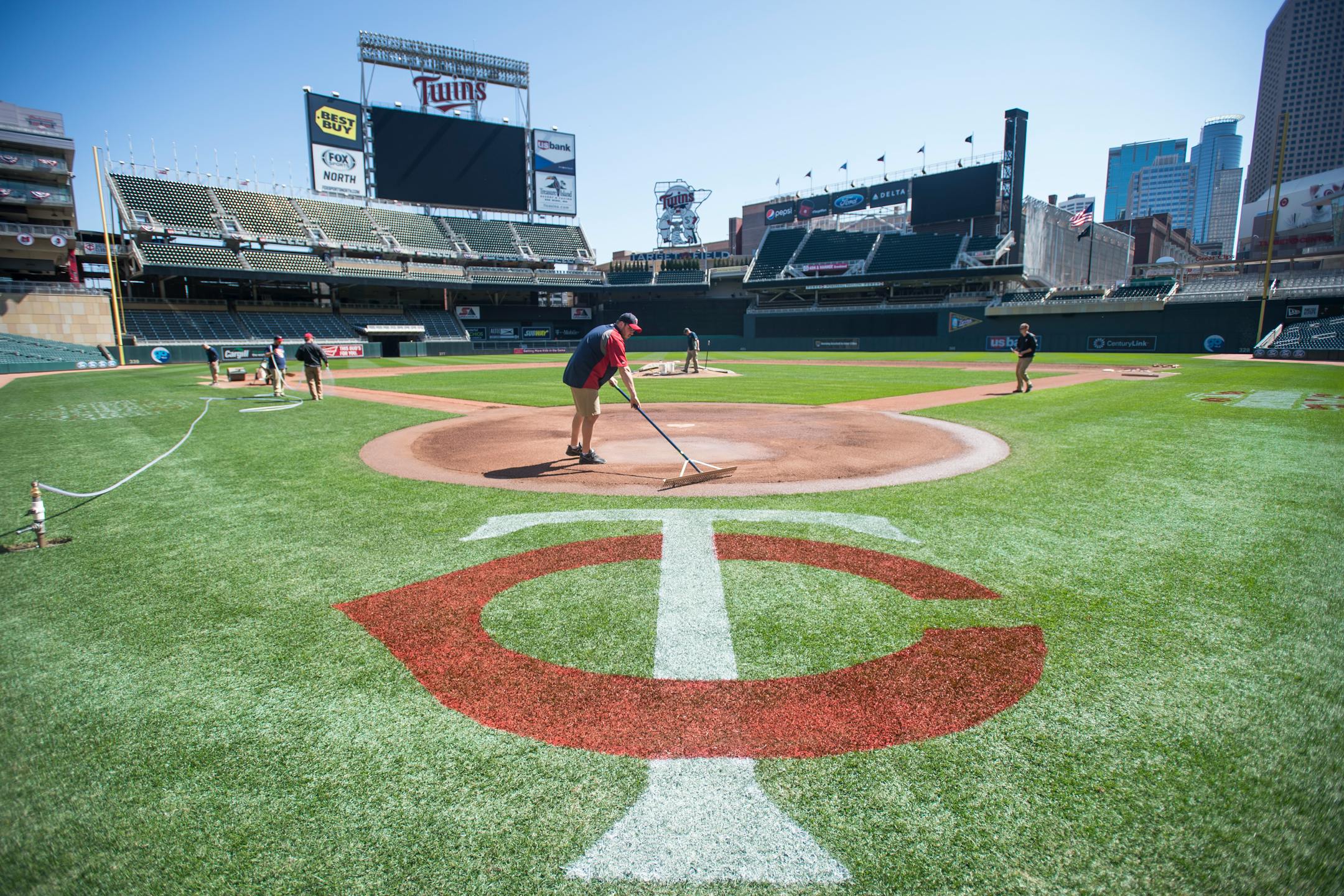 The Twins grounds crew, including Marty Guettinger, left of center, puts the finishing touches on the infield on Saturday afternoon two days before the Twins home opener at Target Field. ] (Aaron Lavinsky | StarTribune) aaron.lavinsky@startribune.com