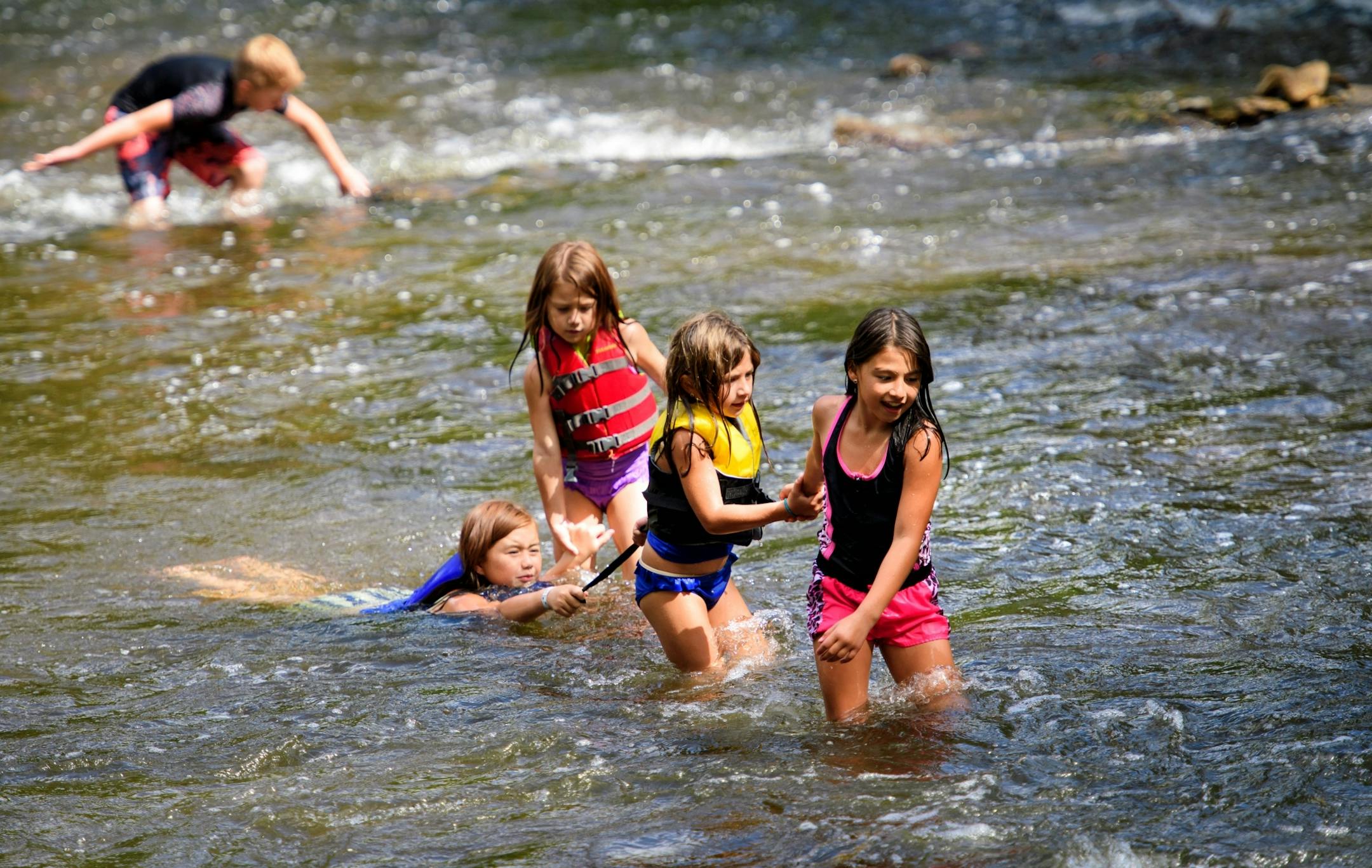 Sisters Alexandra Saito 9, Elizabeth, 7, Madelyn, 6, towed Isabella 10, through the swiftly moving waters below Minnehaha Falls, Minneapolis. Behind them brother Lincoln, 12 hunted for rocks. They recently moved to the Twin Cities from Alaska and were enjoying the Falls.