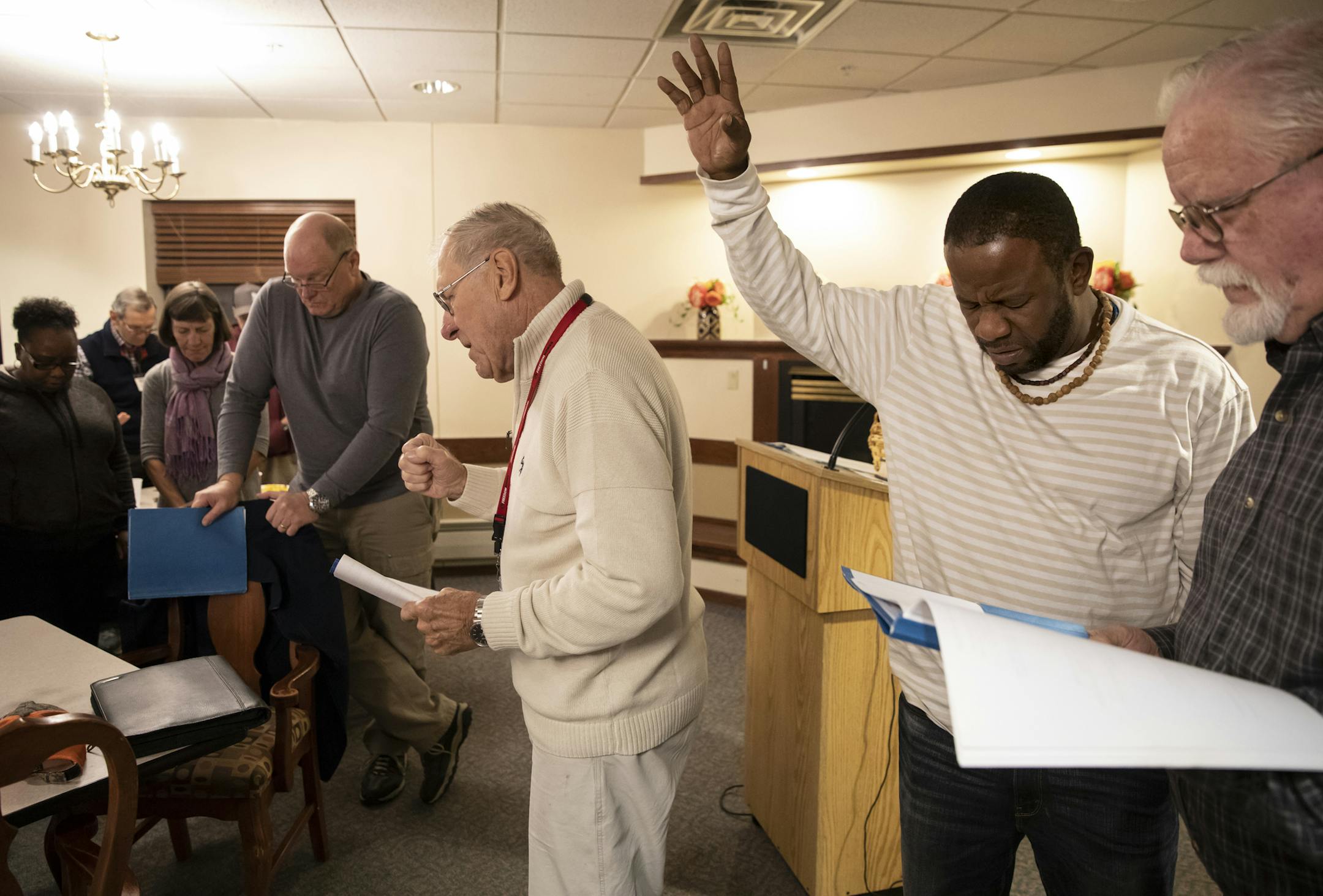 Melvin Broom raised his hands in praise during worship time as Herris Heidenreich, center, led the song "Power in the Blood" at the weekly fellowship meeting in the new FreedomWorks building Minneapolis on Oct. 11. Broom was formerly incarcerated and is now the assistant house manager of the residence.