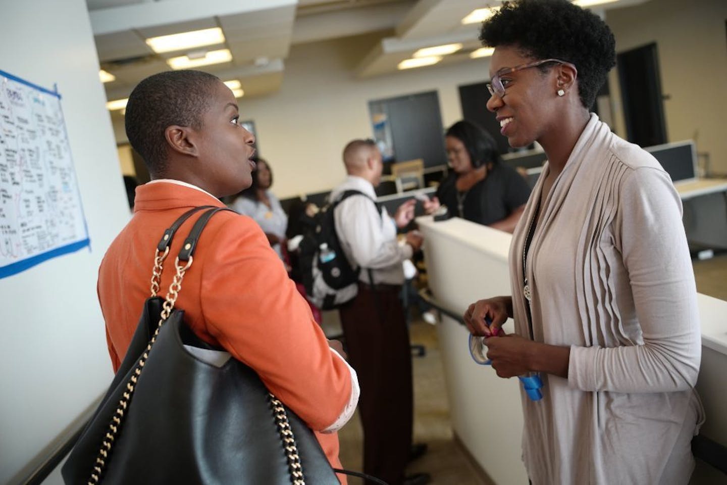 Lasha Raddatz, a real estate broker,left, who is looking to rev up her home sales chats with Julia Israel. Raddatz is definitely interested in increasing home ownership amongst blacks especially. She says," I am the first to go to college, first to have a master, and first to own a home."