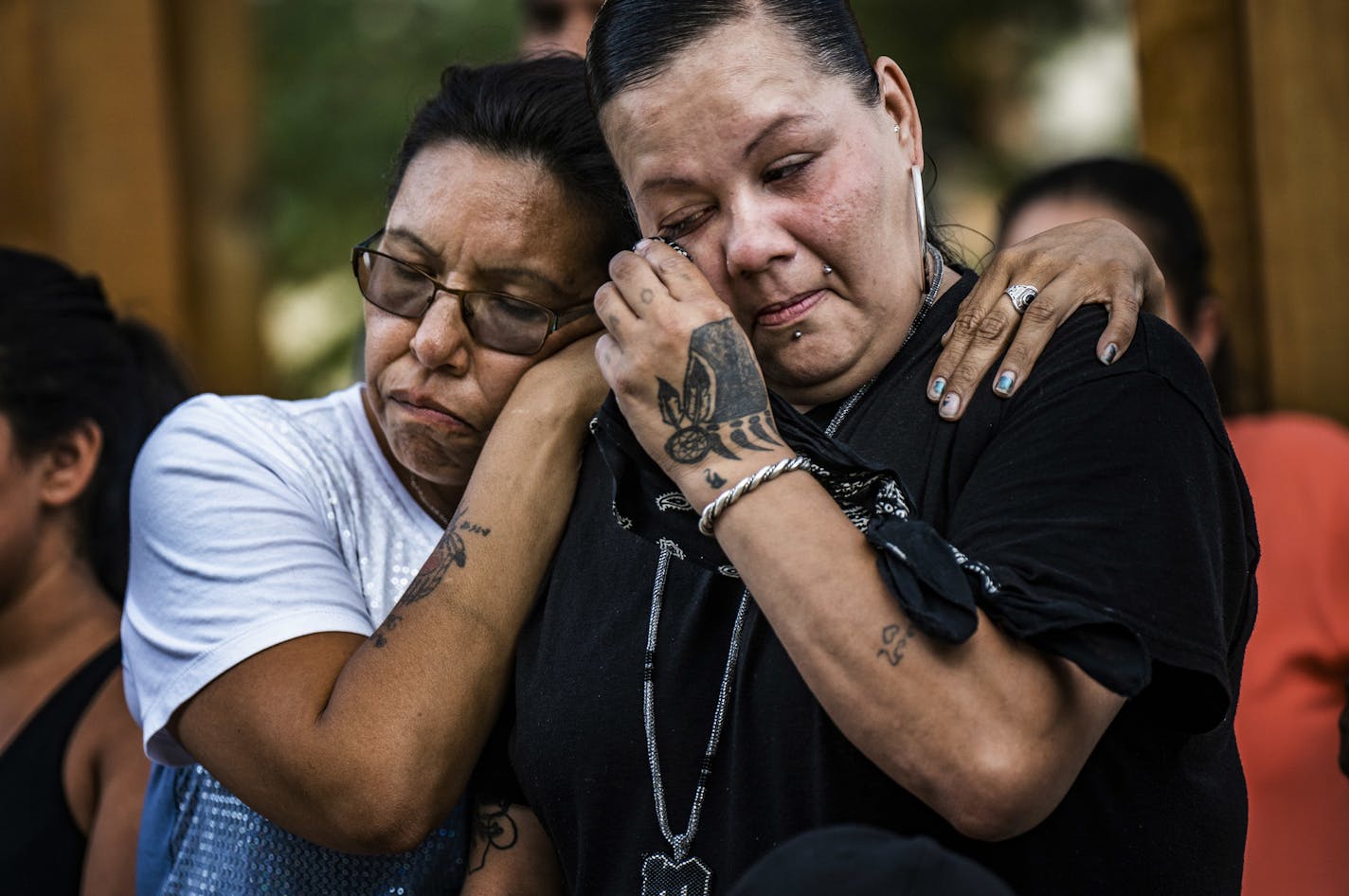 Friend Alicia Smith,left, comforts Melissa Waukazo, the sister of William "Billy" Hughes after a ceremony for her brother on Monday, Aug. 6, 2018 in St. Paul, Minn. The Bureau of Criminal Apprehension said in a statement Tuesday, Aug. 7, that William James Hughes, 43, died of multiple gunshot wounds early Sunday after officers responded to a 911 call of multiple shots fired on the upper floor of the apartment building where he lived. (Richard Tsong-Taatarii/Star Tribune via AP) /Star Tribune via