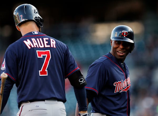 Minnesota Twins right fielder Torii Hunter, right, celebrates his solo home run against the Detroit Tigers with Joe Mauer during the first inning of a