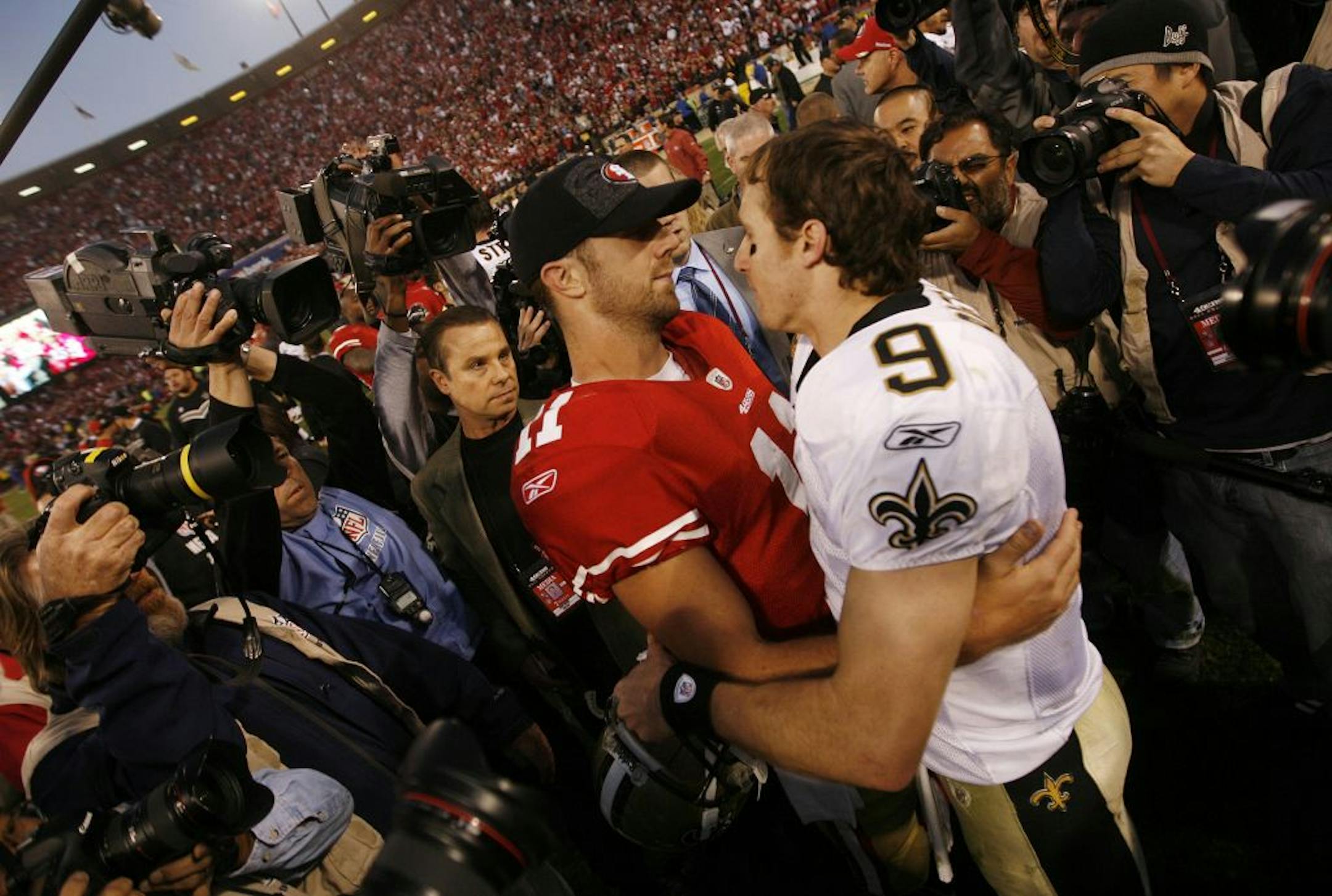 San Francisco 49ers starting quarterback Alex Smith (11) gives New Orleans Saints starting quarterback Drew Brees (9) a hug following a 36-32 49ers win in an NFC divisional playoff game at Candlestick Park in San Francisco, California, Saturday, January 14, 2012. The 49ers defeated the Saints. 36-32.