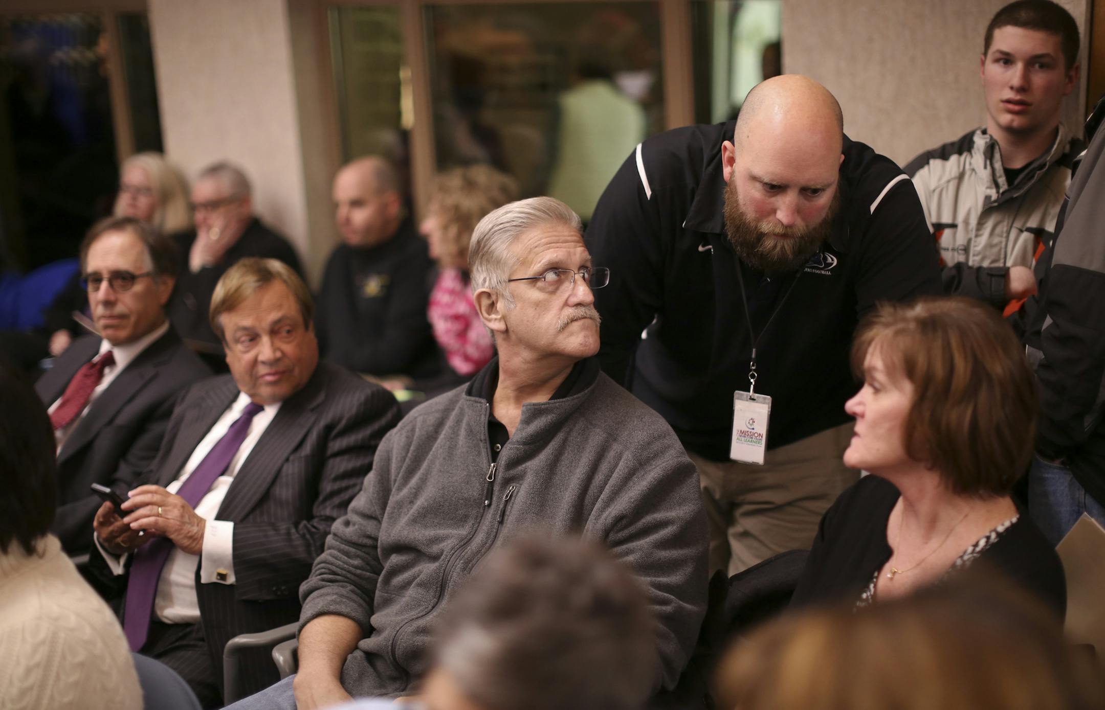 A packed audience attended the Elk River School Board meeting Monday night, February 24, 2014, in the wake of the suspension of a Rogers High School student who was suspended over a Tweet he sent. Rogers High School Spanish teacher B.J. Brent, standing, spoke with the parents of the suspended student, Curt, left, and Lori Sagehorn before the school board met. Brent also addressed the school board during the open forum portion of the meeting. Seated next to the Sagehorns were there attorneys, Ron