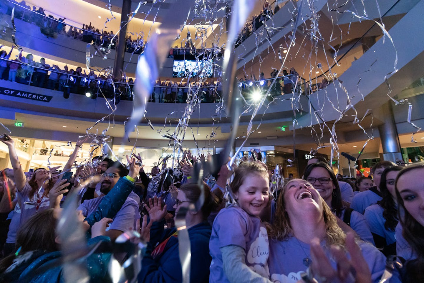 Alizabeth Ludwig, 6, and mother Carrie of Richmond laughed as streamers fell on the Mall of America crowd there to sing "Clouds" on Friday night.