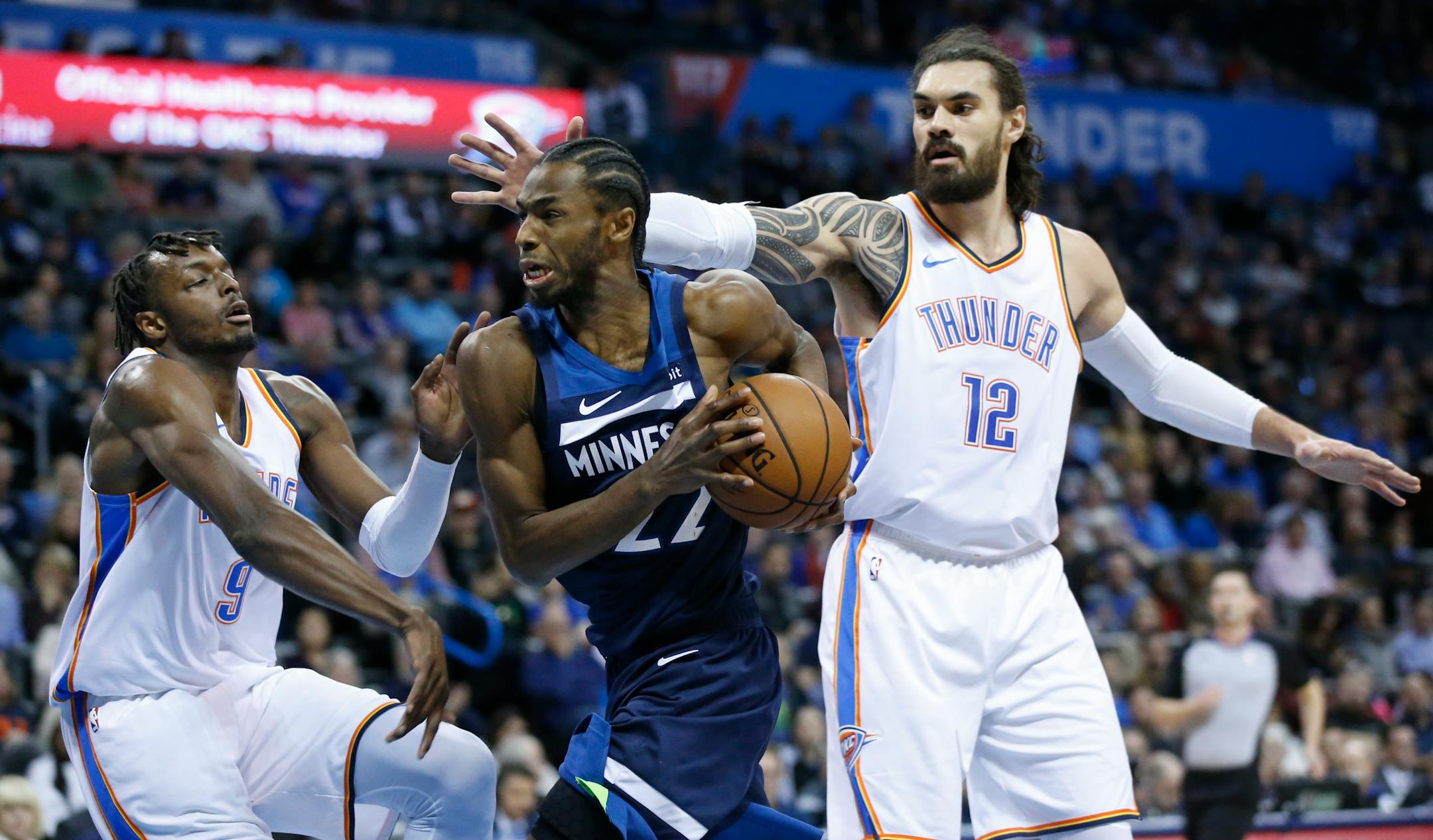 Timberwolves forward Andrew Wiggins drives between Oklahoma City forward Jerami Grant (9) and center Steven Adams (12) in the first half