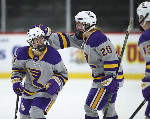 Emma Schmitzwing (7) was congratulated by Rochester Lourdes teammate Kylie VerNess (20) after her first period goal against South St. Paul.