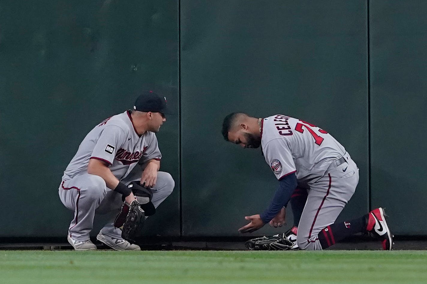 Minnesota Twins center fielder Gilberto Celestino, right, talks with right fielder Alex Kirilloff after Celestino was shaken up after crashing into the wall trying to catch a triple hit by Seattle Mariners' Dylan Moore during the fifth inning of a baseball game, Monday, June 14, 2021, in Seattle. Celestino stayed in the game. (AP Photo/Ted S. Warren)