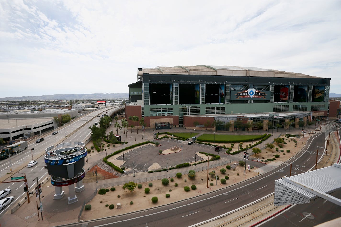 Traffic is extremely light in front of Chase Field, Thursday, March 26, 2020, in Phoenix. The Arizona Diamondbacks would have hosted the Atlanta Braves in their season-opening baseball game Thursday, but the start of the MLB regular season is indefinitely on hold because of the coronavirus pandemic. (AP Photo/Ross D. Franklin) ORG XMIT: AZRF101