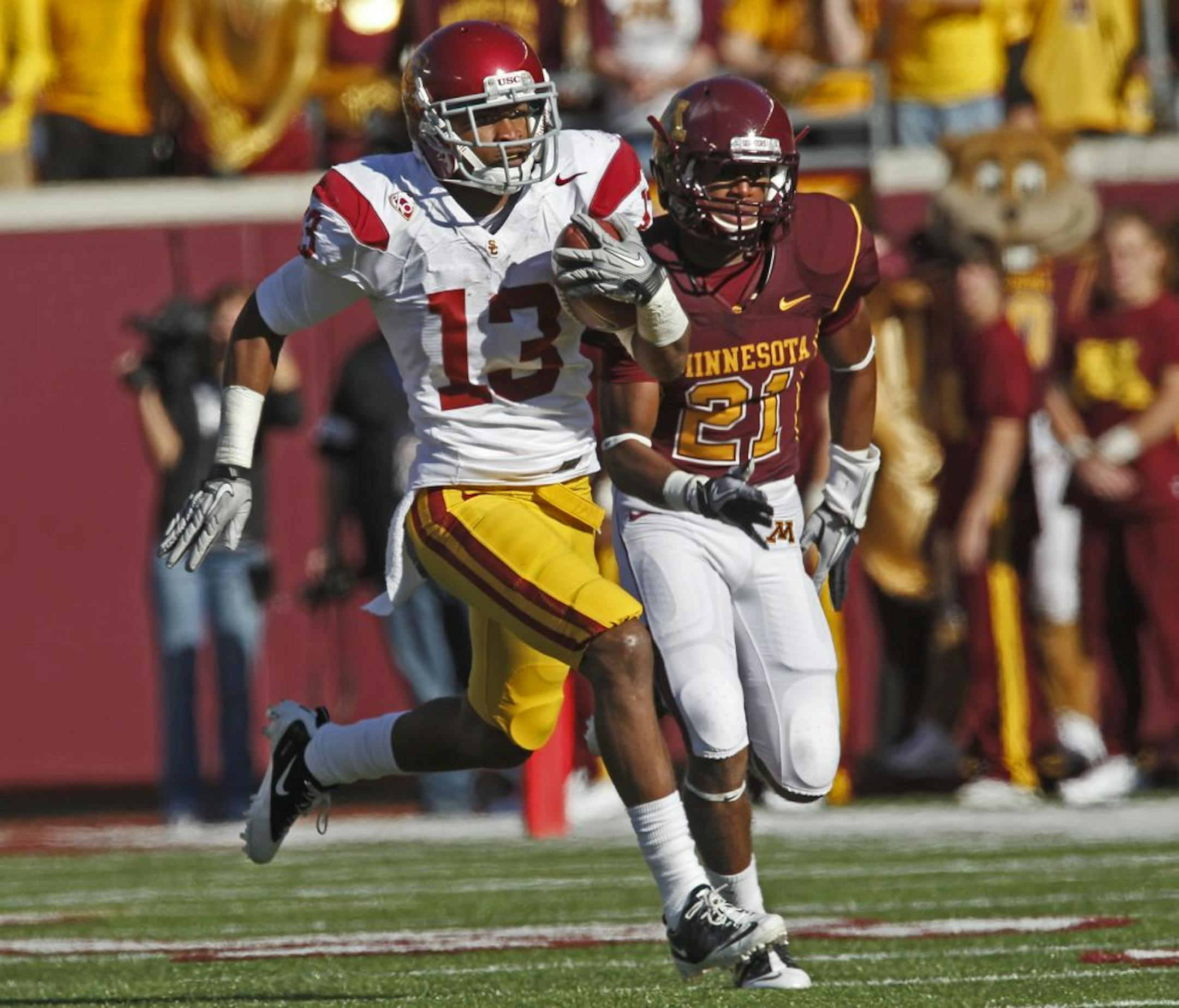 USC kickoff specialist Robert Woods (13) ran a 3rd quarter kickoff back for a 97-yard touchdown run beating Gophers Brock Vereen (21) on the play. The score came on the heels of a Gophers touchdown.