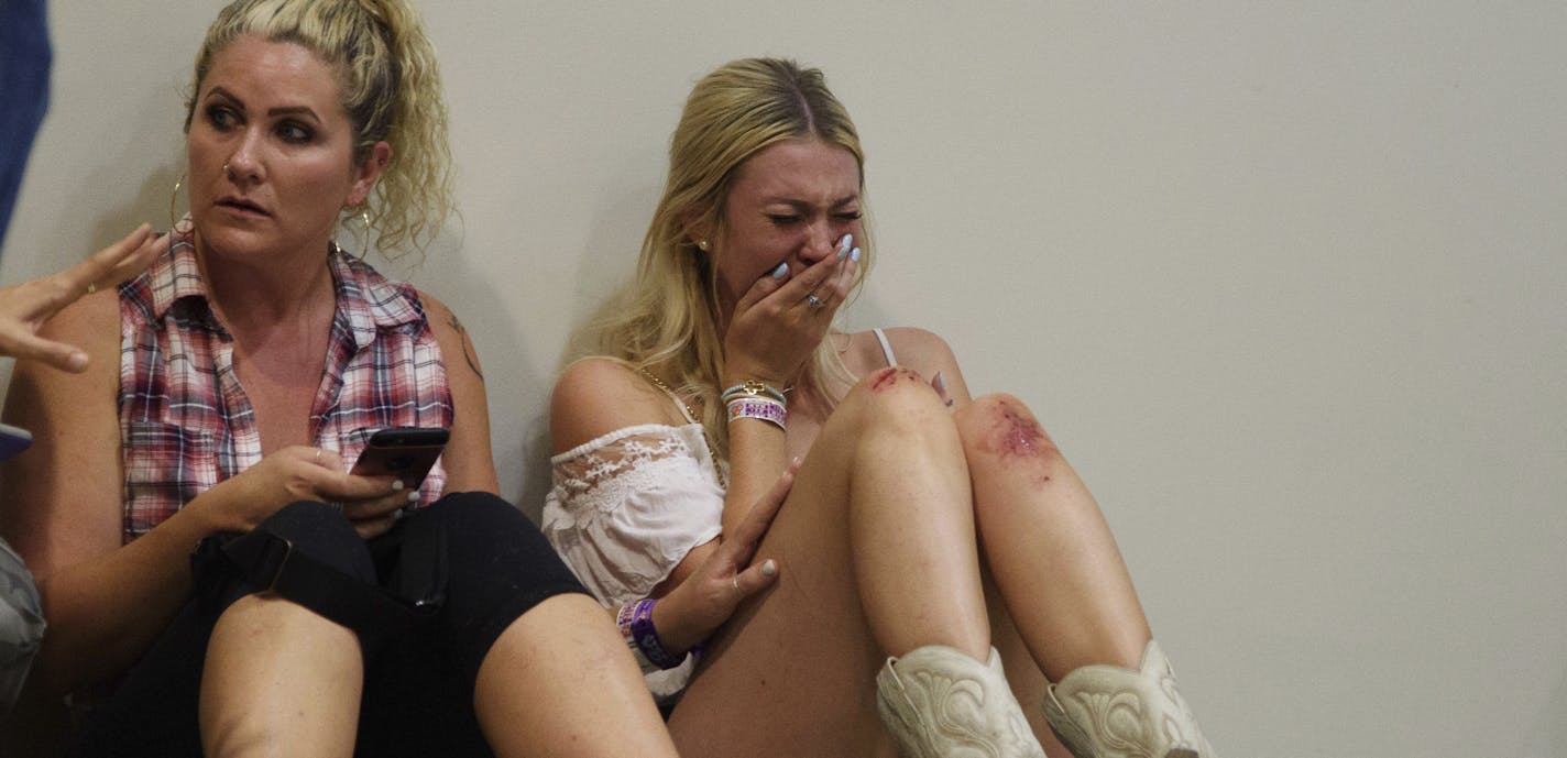 A woman cries while hiding inside the Sands Corporation plane hangar after a mass shooting in which dozens were killed at the Route 91 Harvest Festival on Sunday, Oct. 1, 2017, in Las Vegas. (Al Powers/Invision/AP)