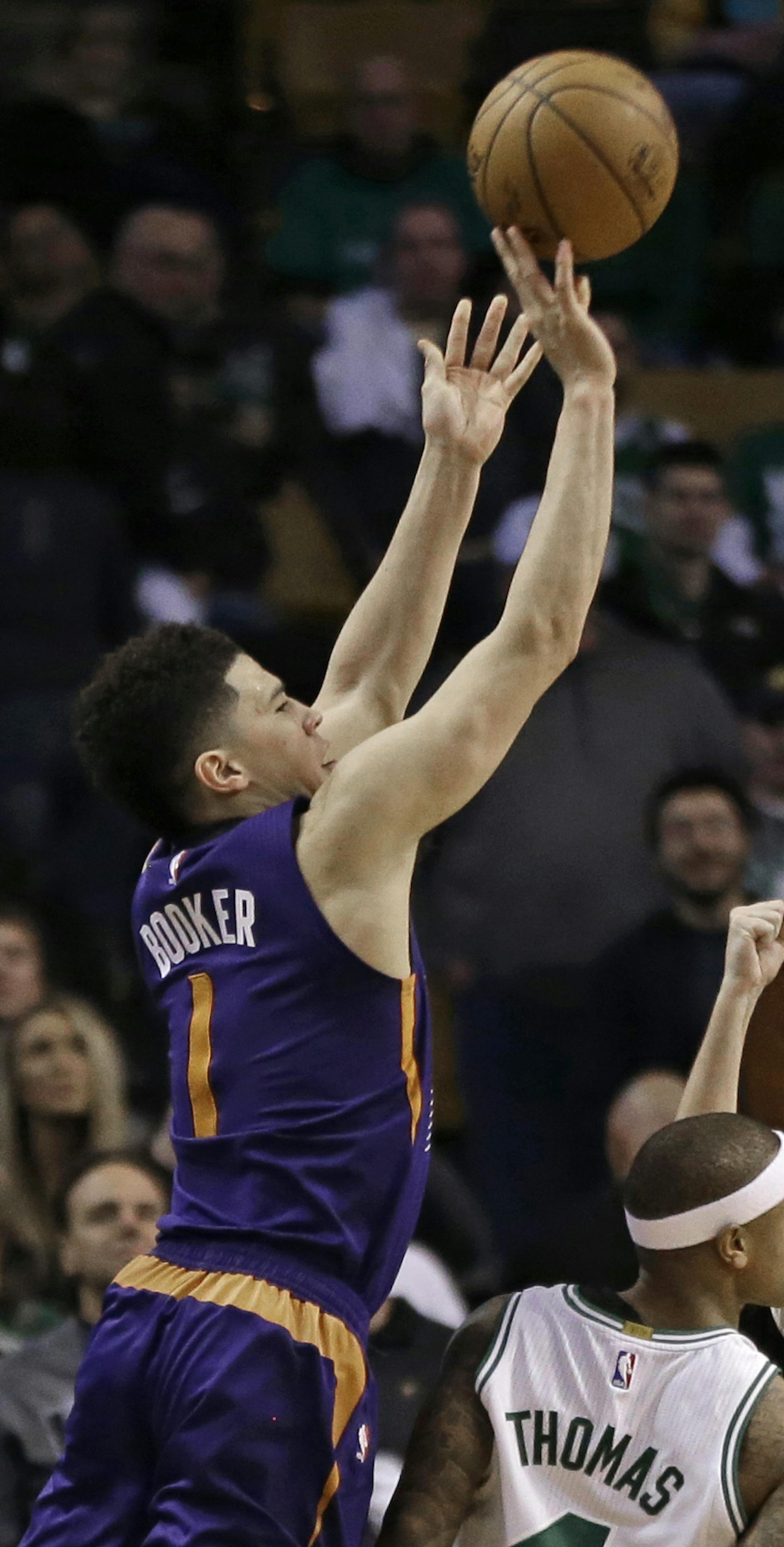 Phoenix Suns guard Devin Booker (1) shoots while being fouled by Boston Celtics guard Isaiah Thomas (4) in the fourth quarter of an NBA basketball game, Friday, March 24, 2017, in Boston. Booker scored 70 points, in their loss to the Celtics, 130-120. Booker is just the sixth player in NBA history to score 70 or more points in a game. (AP Photo/Elise Amendola)