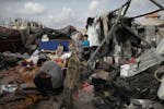 FILE - Displaced Palestinians inspect their tents destroyed by Israel's bombardment, adjunct to an UNRWA facility west of Rafah city, Gaza Strip, on M