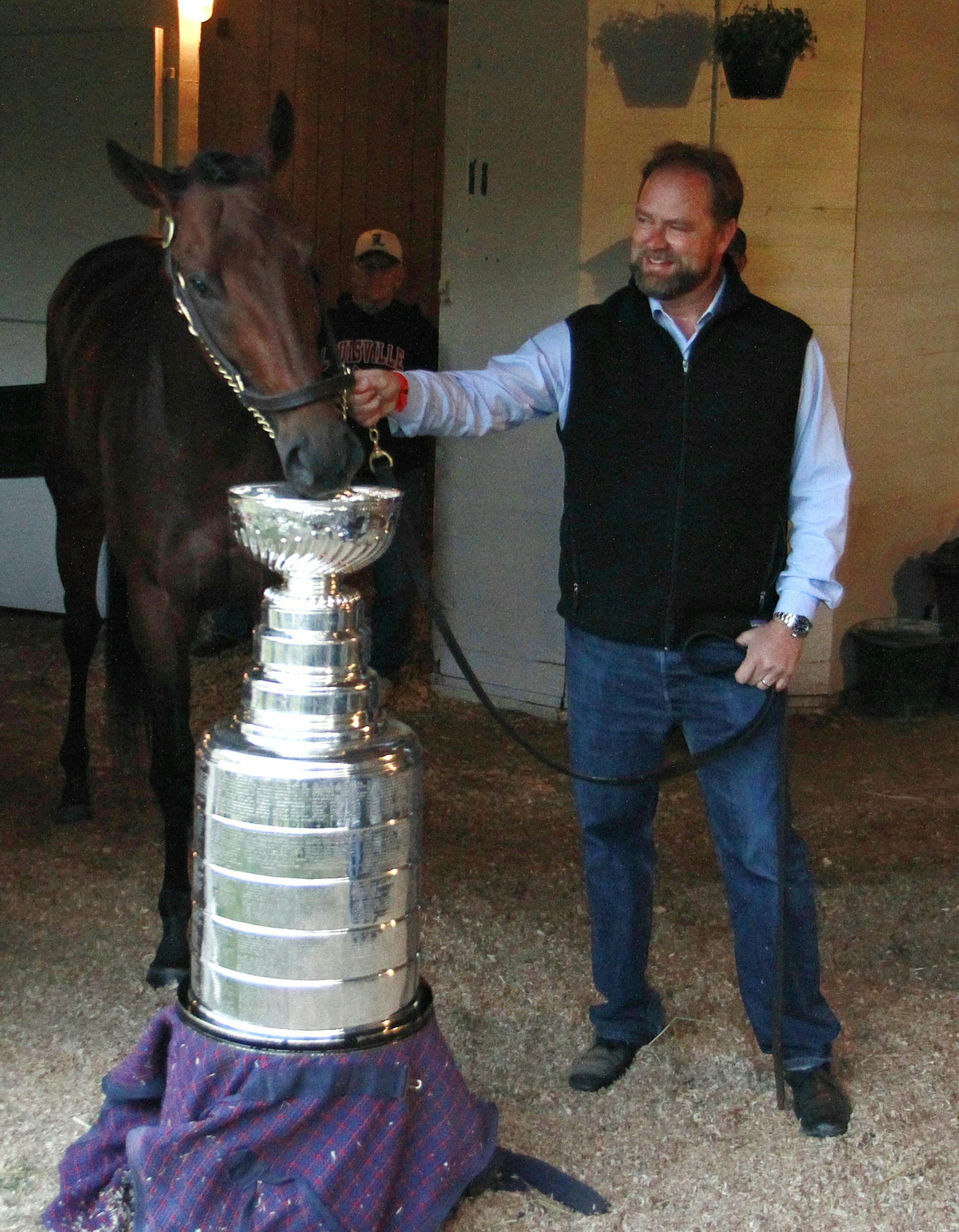 Kentucky Derby entrant Nyquist and trainer Doug O'Neill pose with the Stanley Cup before the 142nd running of the Kentucky Derby horse race at Churchill Downs Saturday, May 7, 2016, in Louisville, Ky. (AP Photo/Garry Jones)