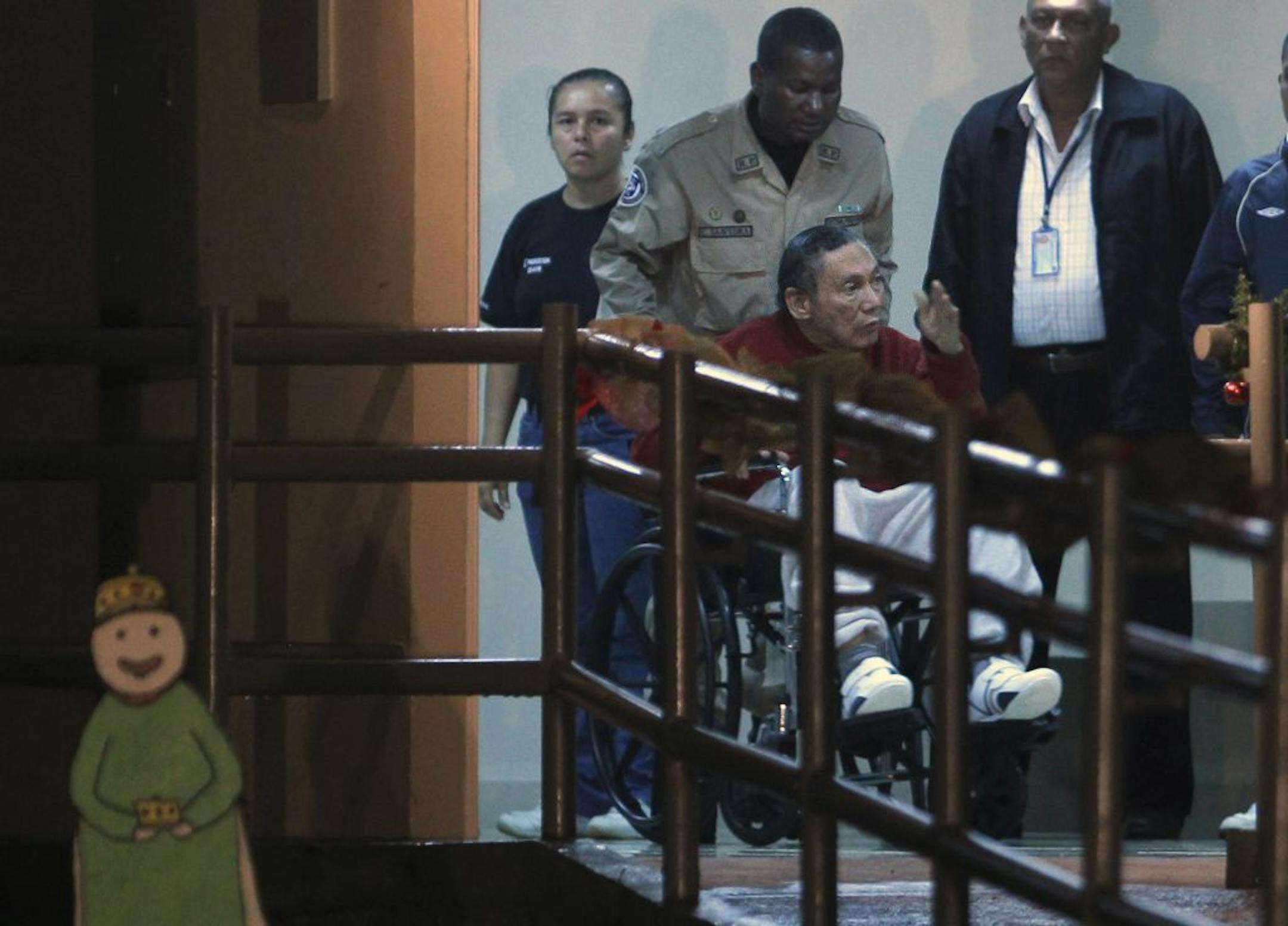 Panama's ex-dictator Manuel Noriega gestures while being carried in a wheelchair by police officers inside El Renacer prison in the outskirts of Panama City, Sunday, Dec. 11, 2011.