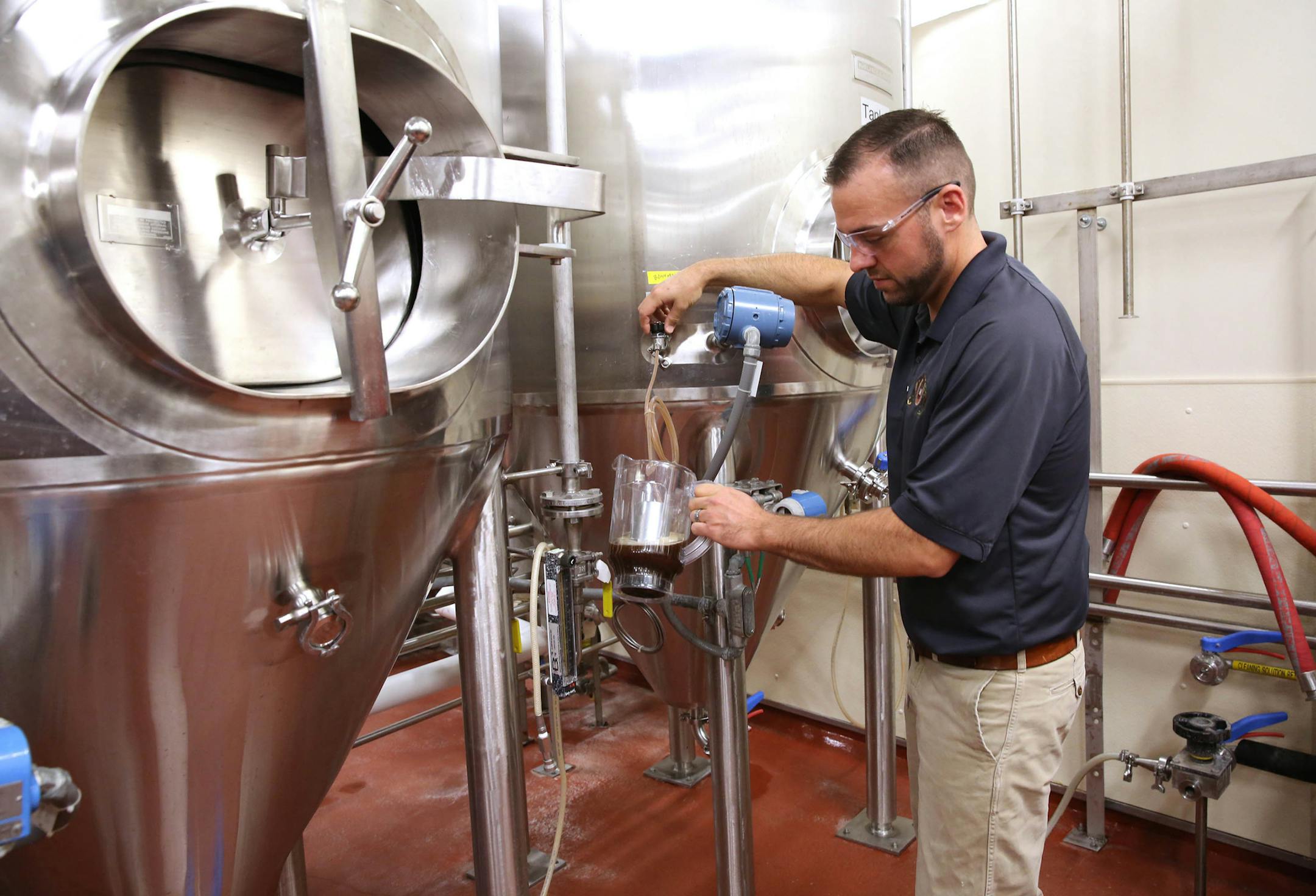 John Kimes, a MillerCoors pilot brewer, pours a sample of the Fred Miller chocolate lager in the fermenting and aging cellar. (Mike De Sisti/Milwaukee Journal Sentinel/TNS) ORG XMIT: 1159954