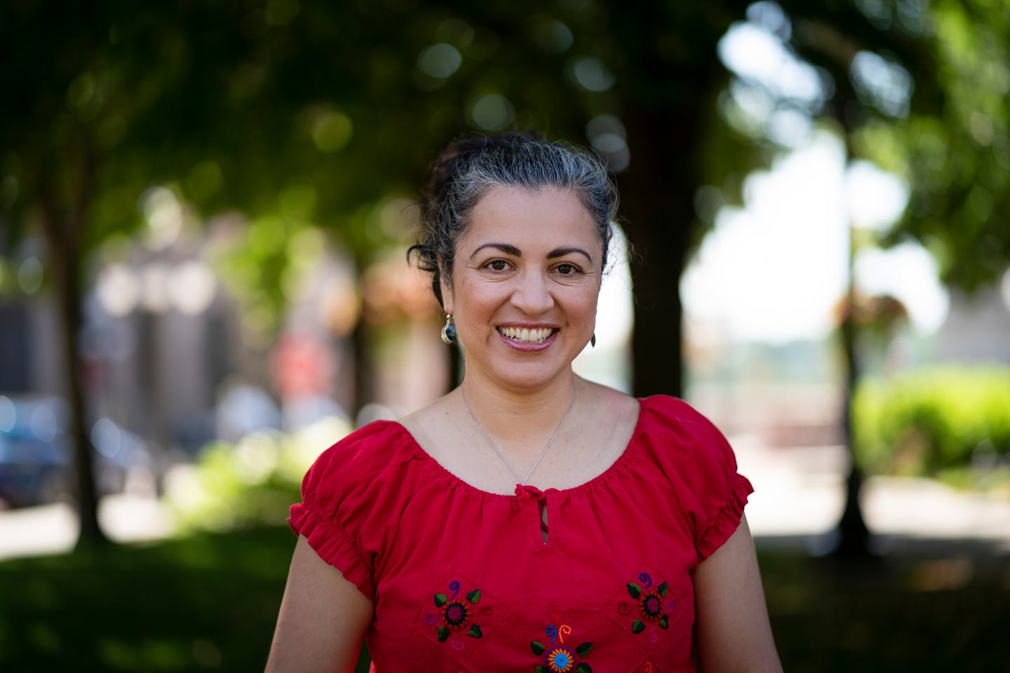 A woman in a red shirt stands in the foreground