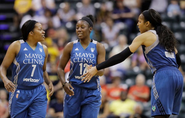 Minnesota Lynx's Maya Moore, right, greets Jia Perkins (7) and Alexis Jones (12) during a timeout in the second half of a WNBA basketball game against