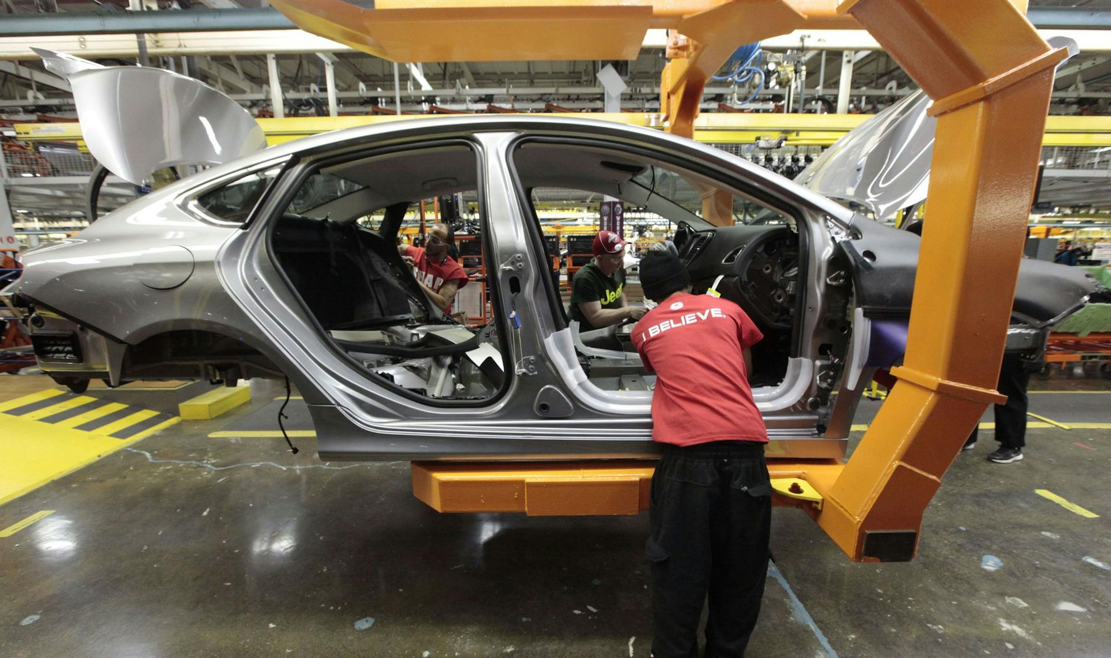 FILE - In this March 14, 2014 file photo, assembly line workers build a 2015 Chrysler 200 automobile at the Sterling Heights Assembly Plant in Sterling Heights, Mich. The United Auto Workers union is threatening to go on strike against Fiat Chrysler after its membership rejected a tentative contract deal with the company. In a Tuesday, Oct. 6, 2015 statement, Fiat Chrysler said that it received a strike notice from the union, and that it continues to work toward reaching an agreement. (AP Photo/