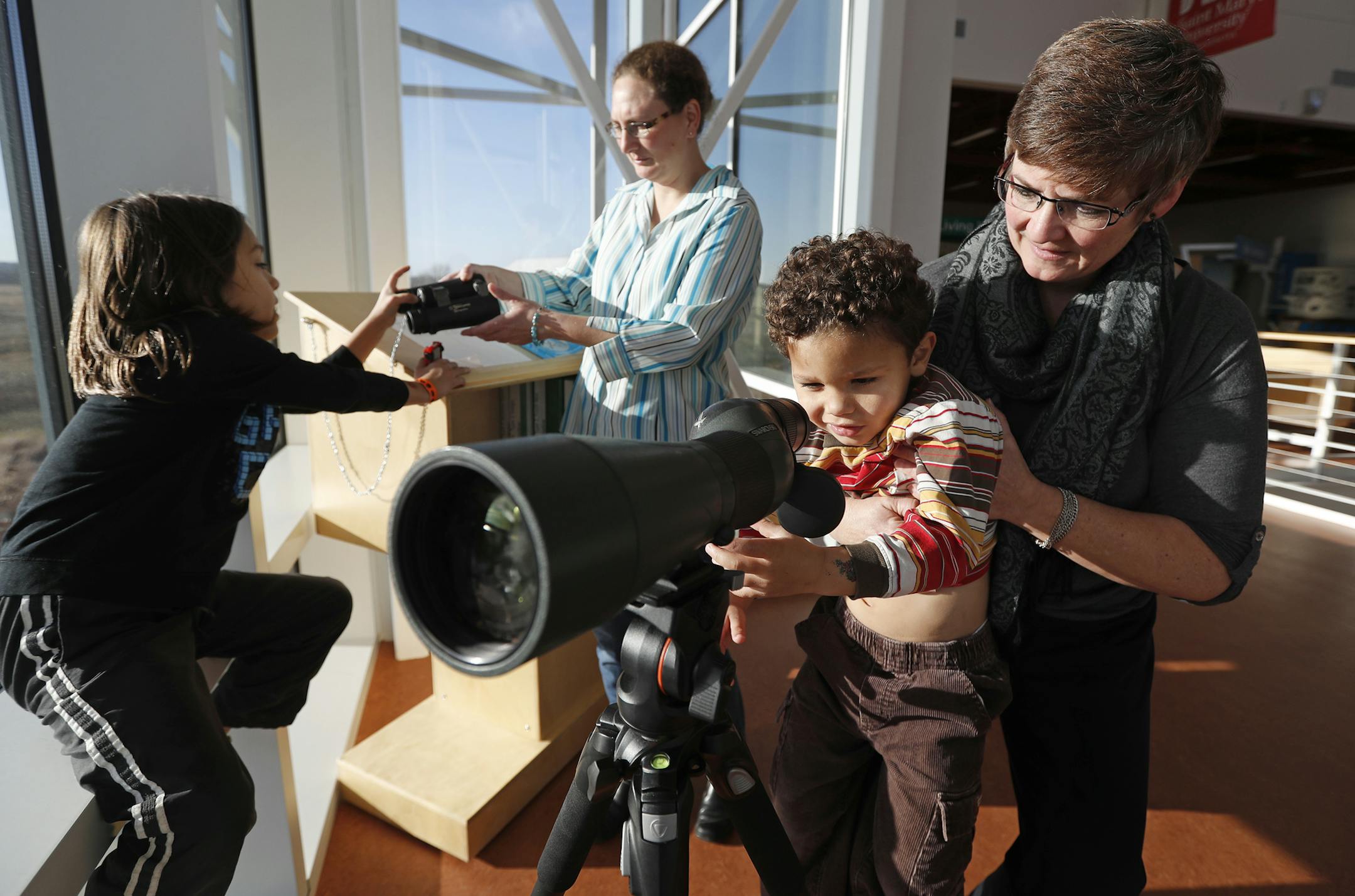 Justin Meier, left, and James Meier play with Erin Meier, standing by a lens, and Pernell Meier at a learning center in Rochester.