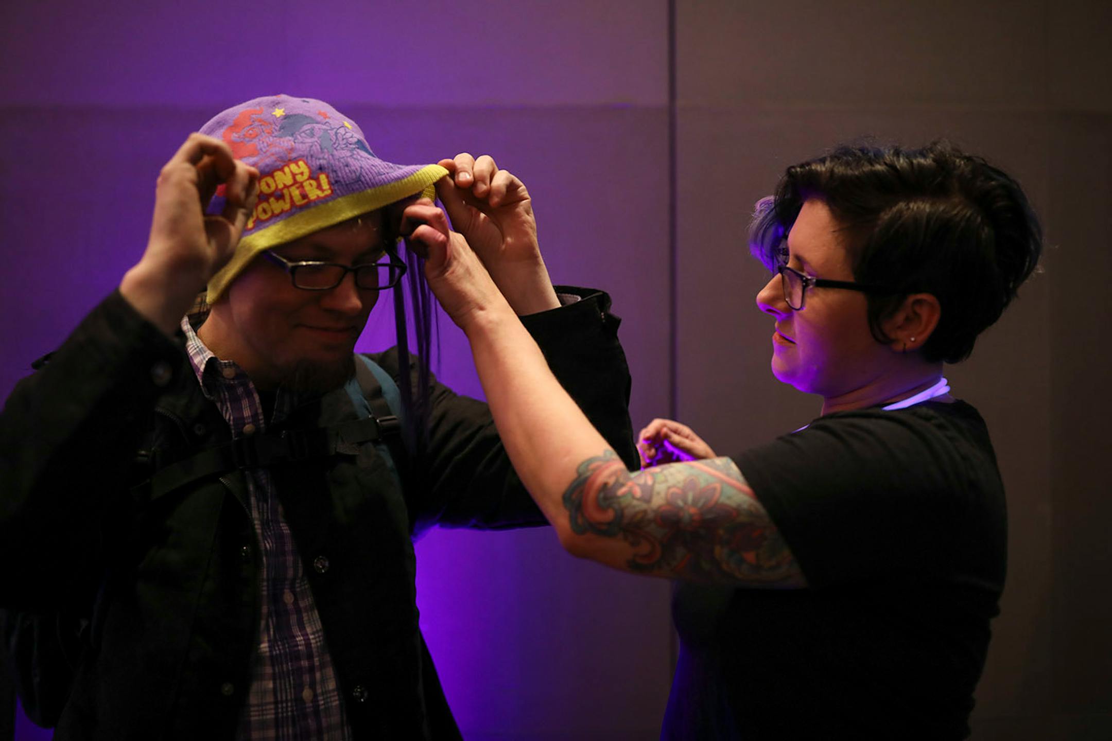 Krishell Bigger gave Nikolaus Thuening a single purple extension to peek out from under his cap at the purple hair station at the entrance to the Guthrie Monday night.