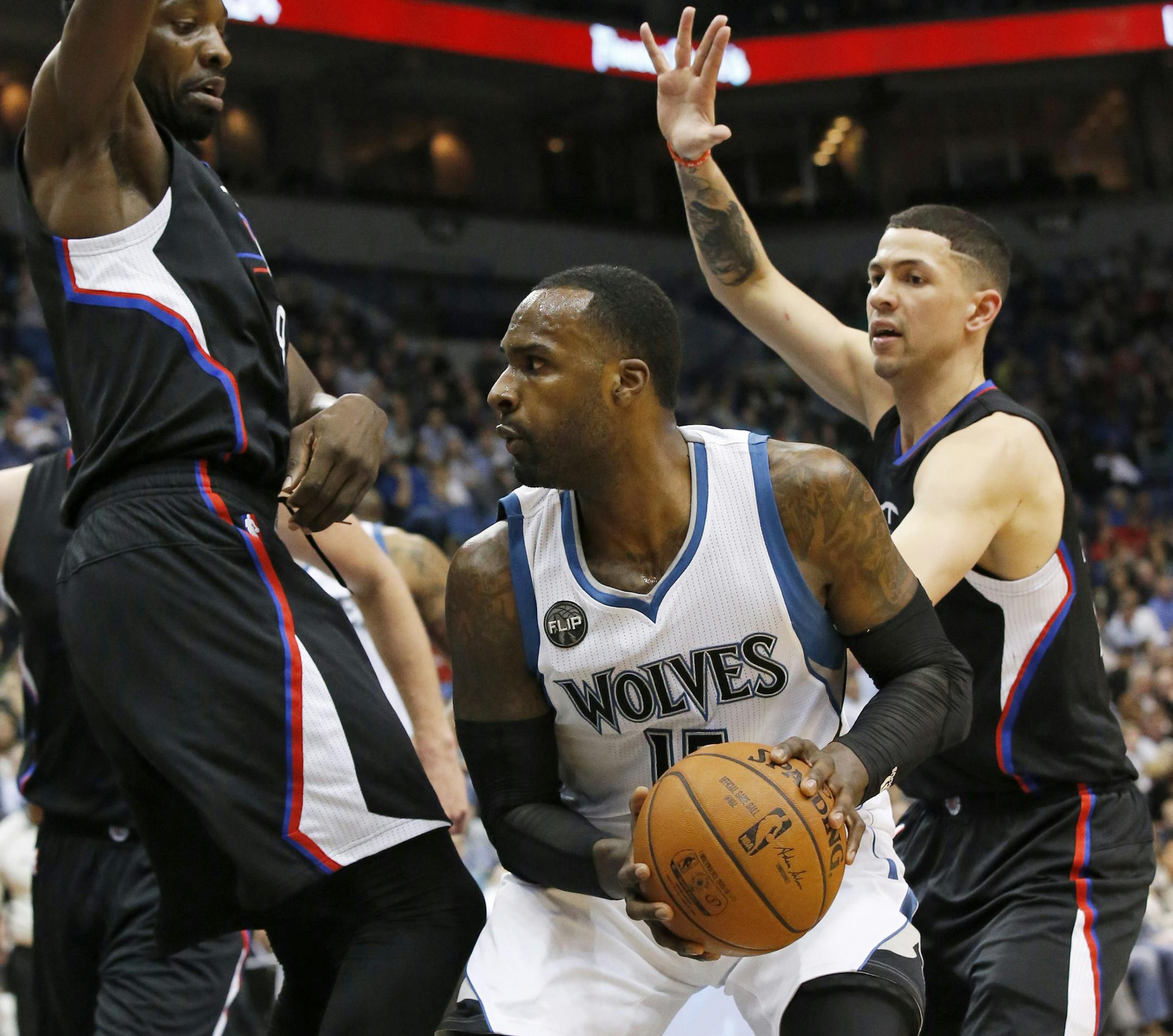 Minnesota Timberwolves forward Shabazz Muhammad, center, tries to get to the basket under pressure from Los Angeles Clippers forward Jeff Green, left, and guard Austin Rivers during the first half of an NBA basketball game in Minneapolis, Wednesday, March 30, 2016. (AP Photo/Ann Heisenfelt)