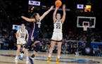 Iowa guard Caitlin Clark (22) shoots a three-point basket over UConn guard Nika Muhl (10) during the second half of a Final Four college basketball ga