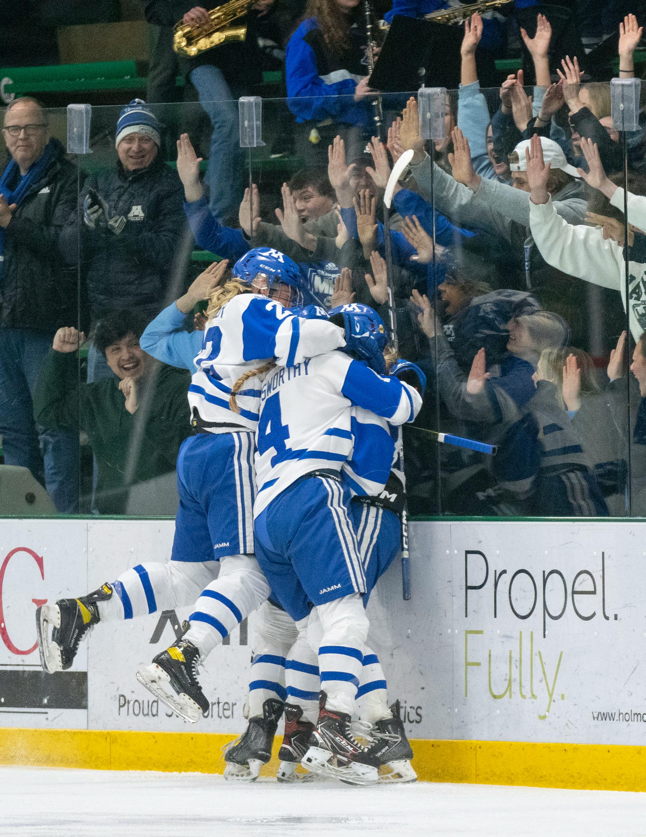 Minnetonka players swarm forward Lindzi Avar (13) after Avar scored a goal against Holy Family in the second period.