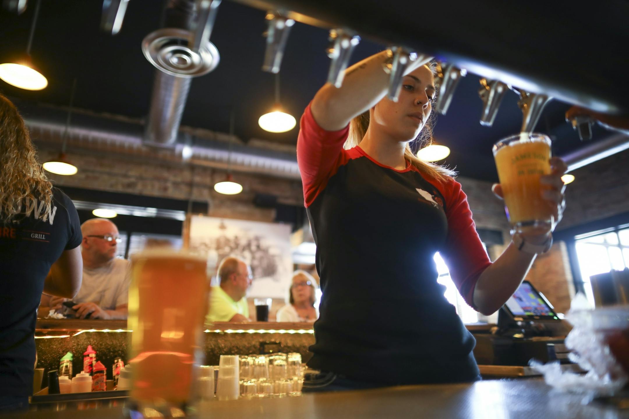 Bartender Jen Spector poured a tap beer for a customer at Boomtown Brewery & Woodfire Grill last week.
