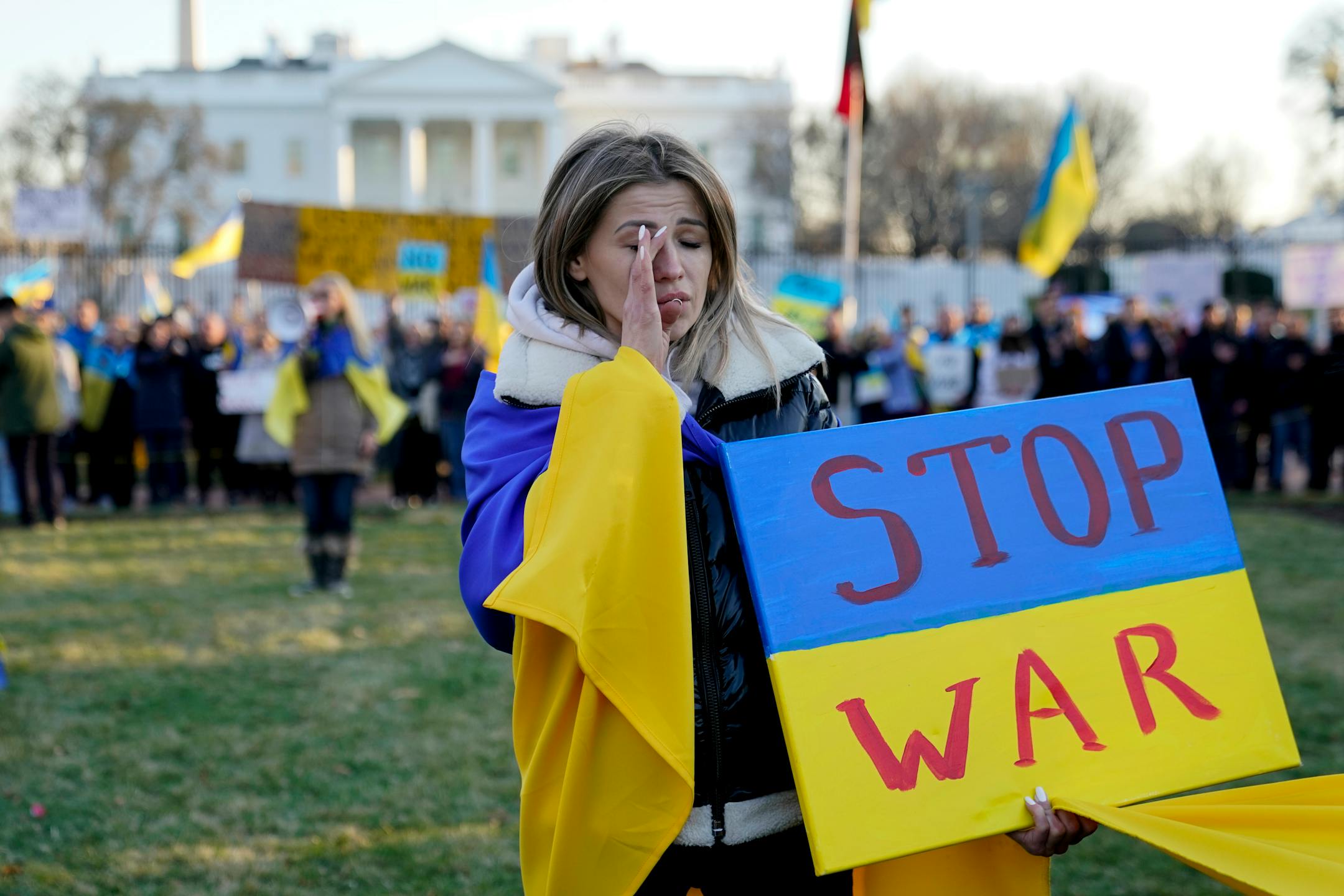 A protester wipes away tears as she takes part in a protest against the Russian invasion of Ukraine outside the White House in Washington, Sunday, Feb. 27, 2022. (AP Photo/Patrick Semansky)
