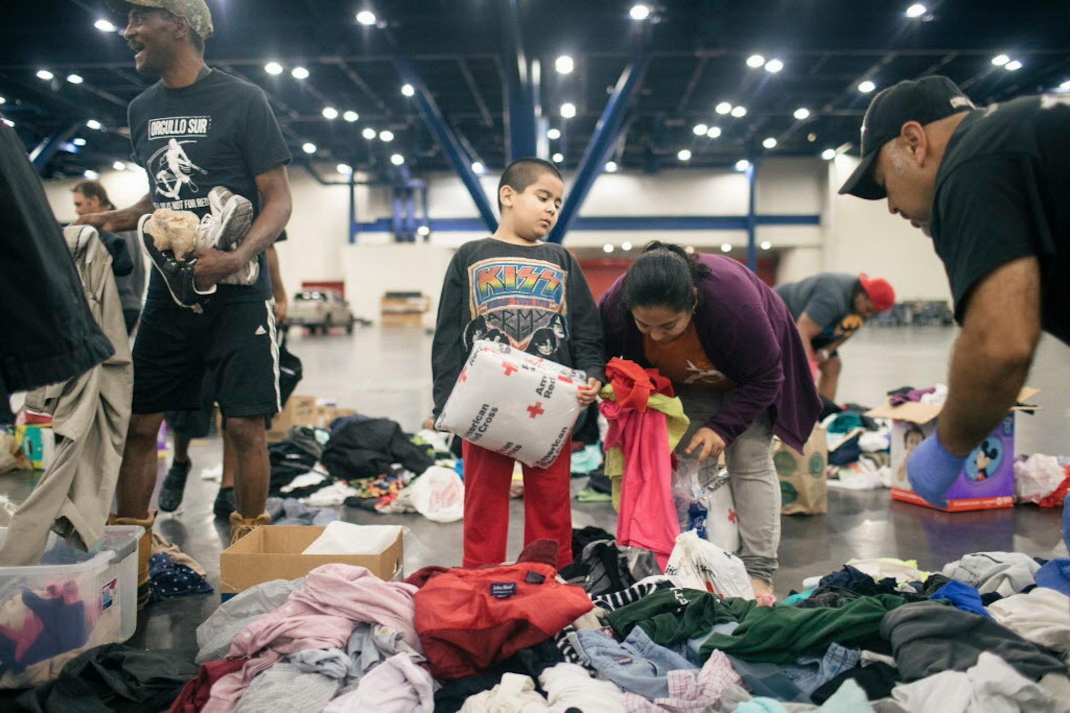 Iban Martinez, 7, holds a Red Cross blanket as his mother looks for new, dry clothes for their family at a temporary shelter at the George R. Brown Convention Center in downtown Houston, Aug. 27, 2017.