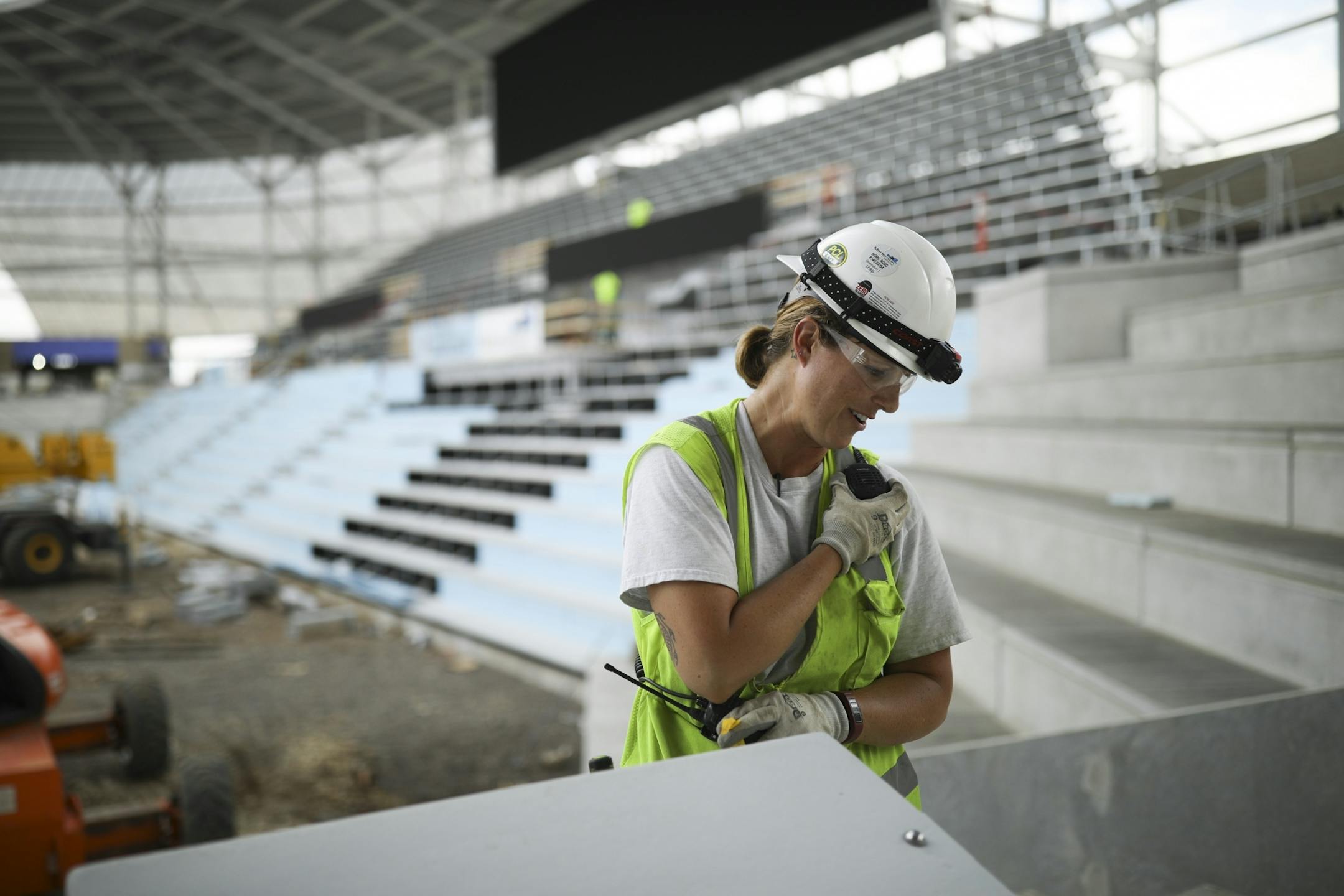 Vanessa Sanders, spoke with a coworker by radio after readying a pair of huge speakers to be hung from the roof of Allianz Field. She's an apprentice electrician working with low voltage installations for Parsons Electric.