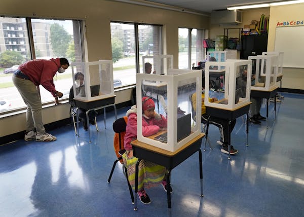 It was back to school for some students at Harvest Best Academy Tuesday in Minneapolis, but with masks, plastic barriers and other new precautions in 
