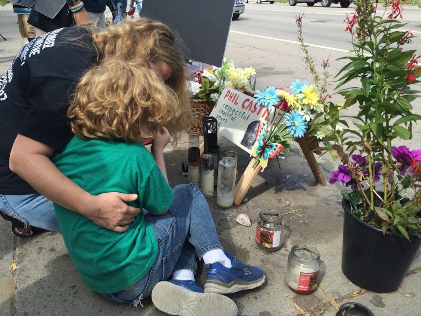 Photo by Liz Sawyer: Rachel Wannarka, St. Paul, and her son, Elliot, 8, were among those mourning at the site of Castile's shooting on Saturday. "My black son deserves to be as safe on the street as my white son," Wannarka said.