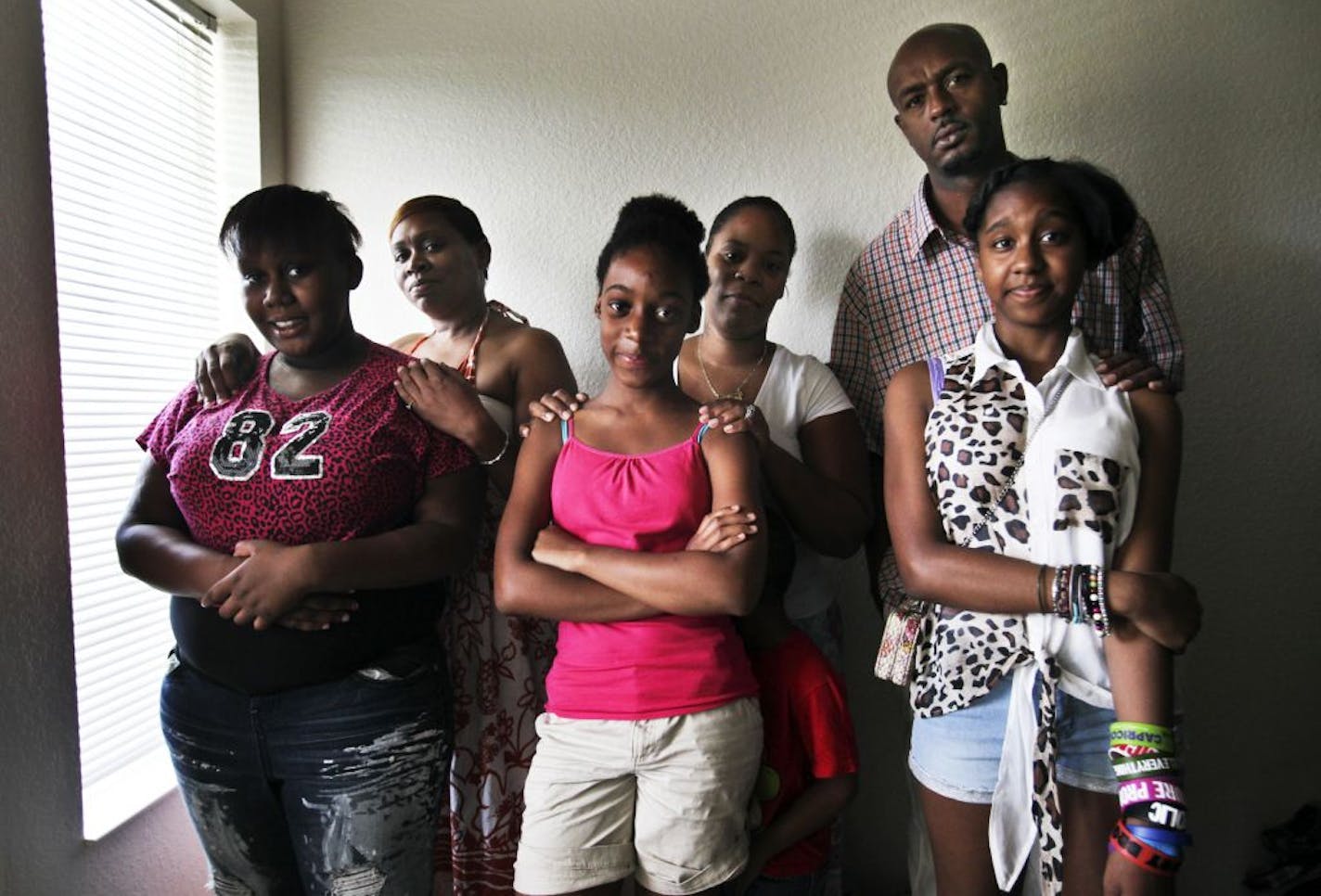 Melissa Dobbs, 13, front, left to right, Jamia Ware, 12, and Aulecia Jones, 12, attended Heights Community School in St. Paul, where the girls were among pupils harassed by a former teacher, say their parents and guardians. Behind the girls is Vanessa Boyd, left, Melissa and Jamia's grandmother, Latasha Tolbert, Jamia's mother, and Miguel Jones, Aulecia's father.