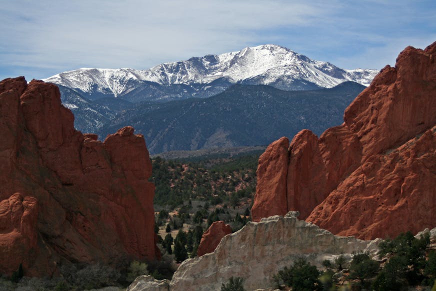 A view of Pikes Peak framed by the red rock formations of the Garden of the Gods in Colorado.