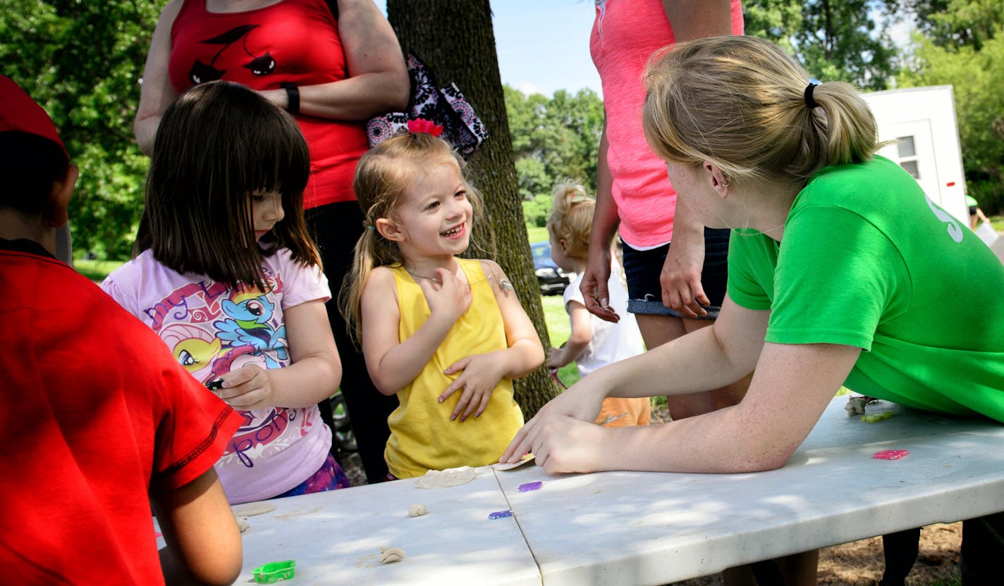 Puppeteer Peyton Banick helped 4-year-old fans Zoe, left, and Abby with an art project between puppet shows. Each show includes activities along with the performance.