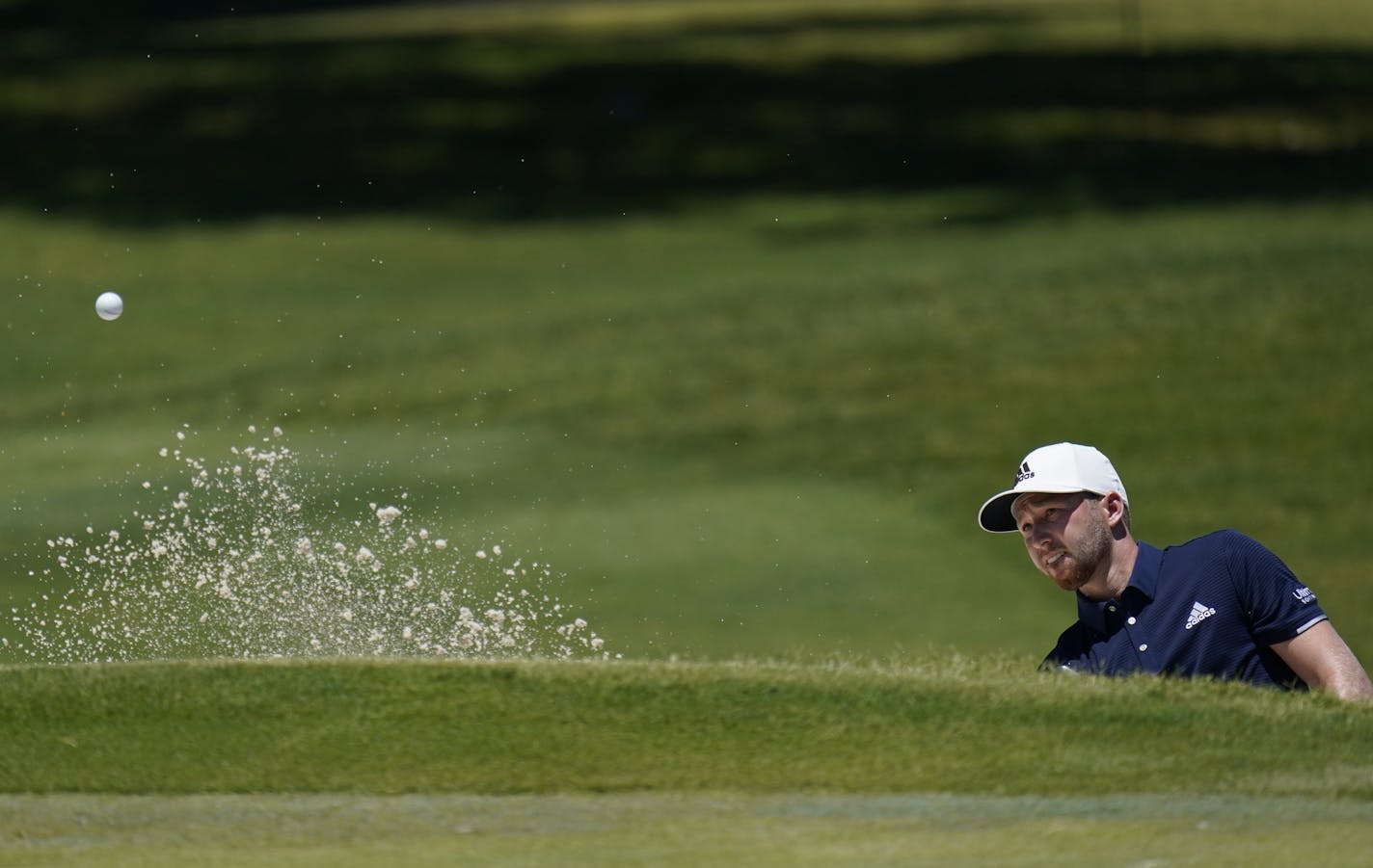 Daniel Berger hits out of a bunker on the first hole during the final round of the Charles Schwab Challenge golf tournament at the Colonial Country Club in Fort Worth, Texas, Sunday, June 14, 2020. (AP Photo/David J. Phillip)