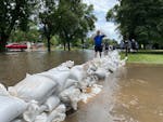 Randy Evers of Windom, Minn., stacks sandbags at the home of his friend Joe Fischenich, after flooding that swamped parts of the town June 22, 2024.