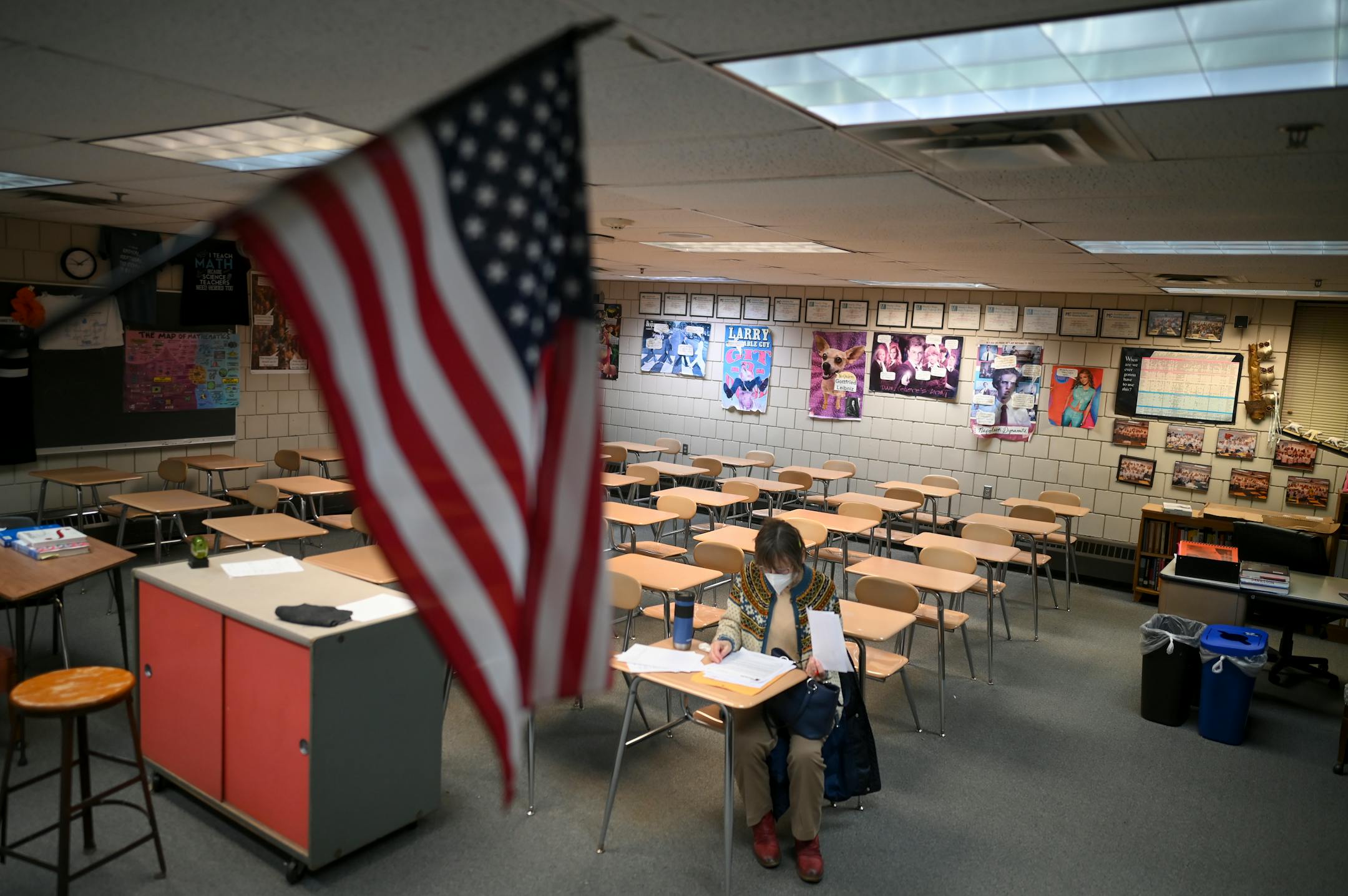 While many rooms were full, Kathy Seitz, from Oakdale's precinct four, sits alone in a room due to low turnout in her precinct during a GOP Caucus Tuesday, Feb. 1, 2022 at White Bear Lake Area High School in White Bear Lake, Minn. She says she just moved to Oakdale in May and she's been used to standing room only caucuses in her previous experiences.