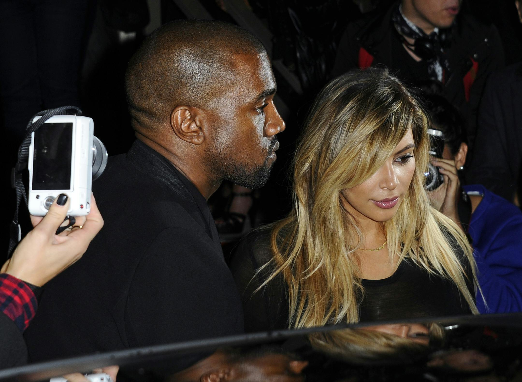 FILE - In this Sept. 29, 2013 file photo, Kanye West, left, and Kim Kardashian leave after attending Givenchy's ready-to-wear Spring/Summer 2014 fashion collection in Paris. Marriage is coming after the baby carriage for Kim Kardashian and Kanye West. E! News reports West proposed to Kardashian Monday, Oct. 21, 2013, on Kardashian's 33rd birthday, in front of family and friends at the AT&T Park. Kardashian gave birth to the coupleís first child, daughter North West, in June. Representatives