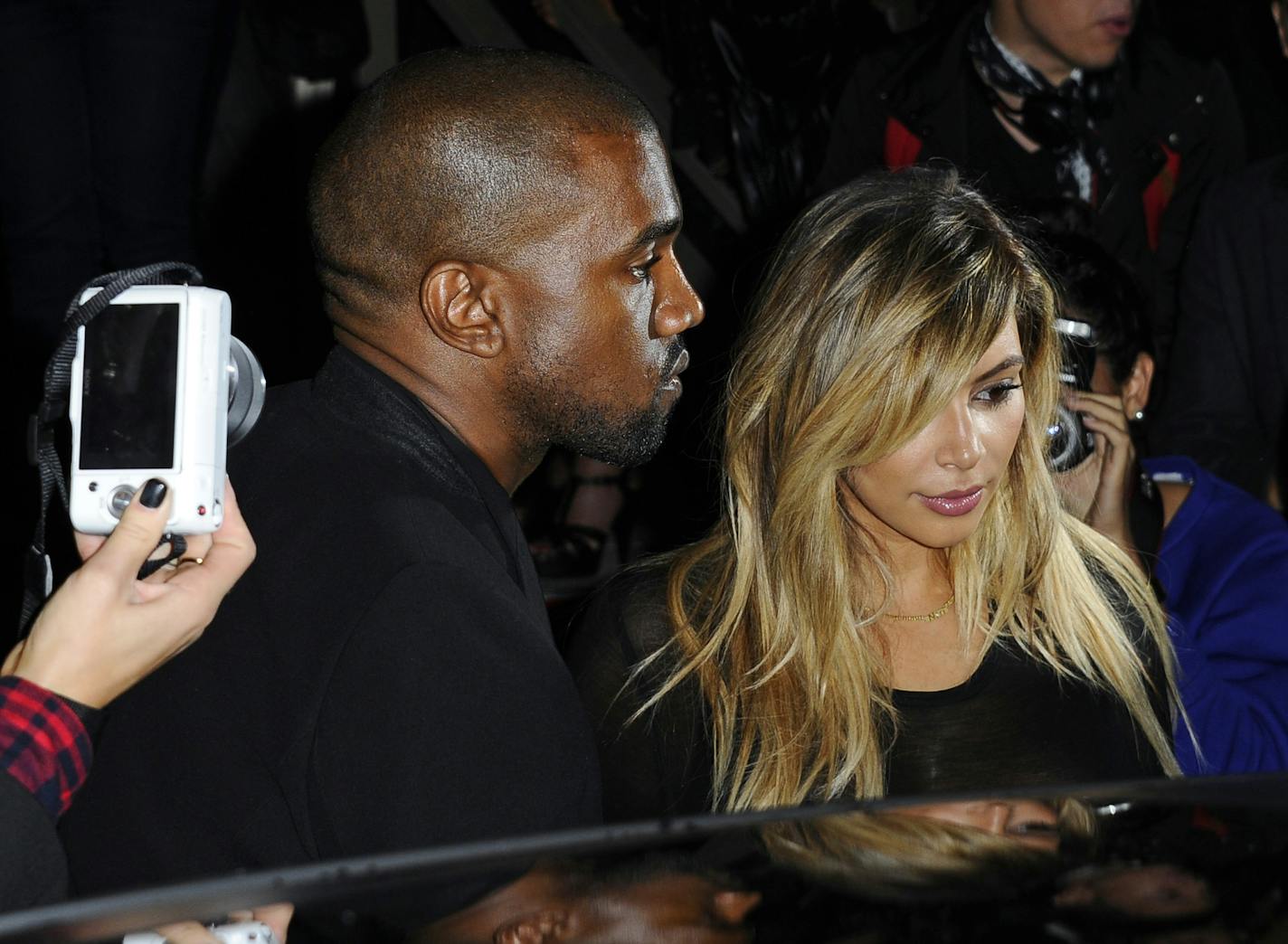 FILE - In this Sept. 29, 2013 file photo, Kanye West, left, and Kim Kardashian leave after attending Givenchy's ready-to-wear Spring/Summer 2014 fashion collection in Paris. Marriage is coming after the baby carriage for Kim Kardashian and Kanye West. E! News reports West proposed to Kardashian Monday, Oct. 21, 2013, on Kardashian's 33rd birthday, in front of family and friends at the AT&T Park. Kardashian gave birth to the couple&#xed;s first child, daughter North West, in June. Representatives